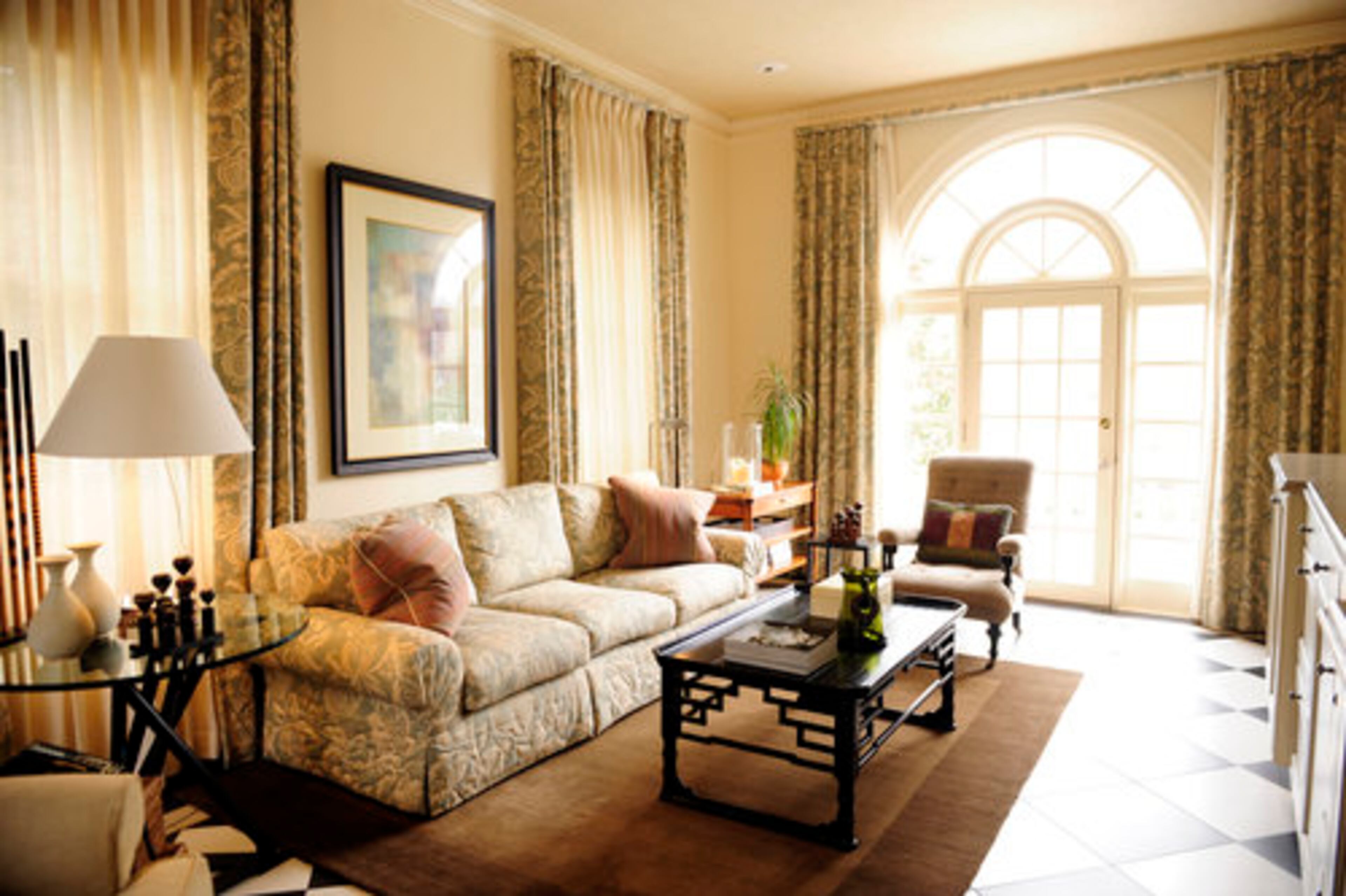 Since completing the family room renovation in 2007, the couple loves to hang out here because of its proximity to the kitchen and comfortable style. The ceiling was covered with rice paper "to give it a warm, interesting touch," he says. The taupe-colored cabinets store a wine cooler and are topped with marble. The floor was converted from terra cotta tile to this black-and-white flooring, which picks up the floor pattern in the bar. Only here it's heated.