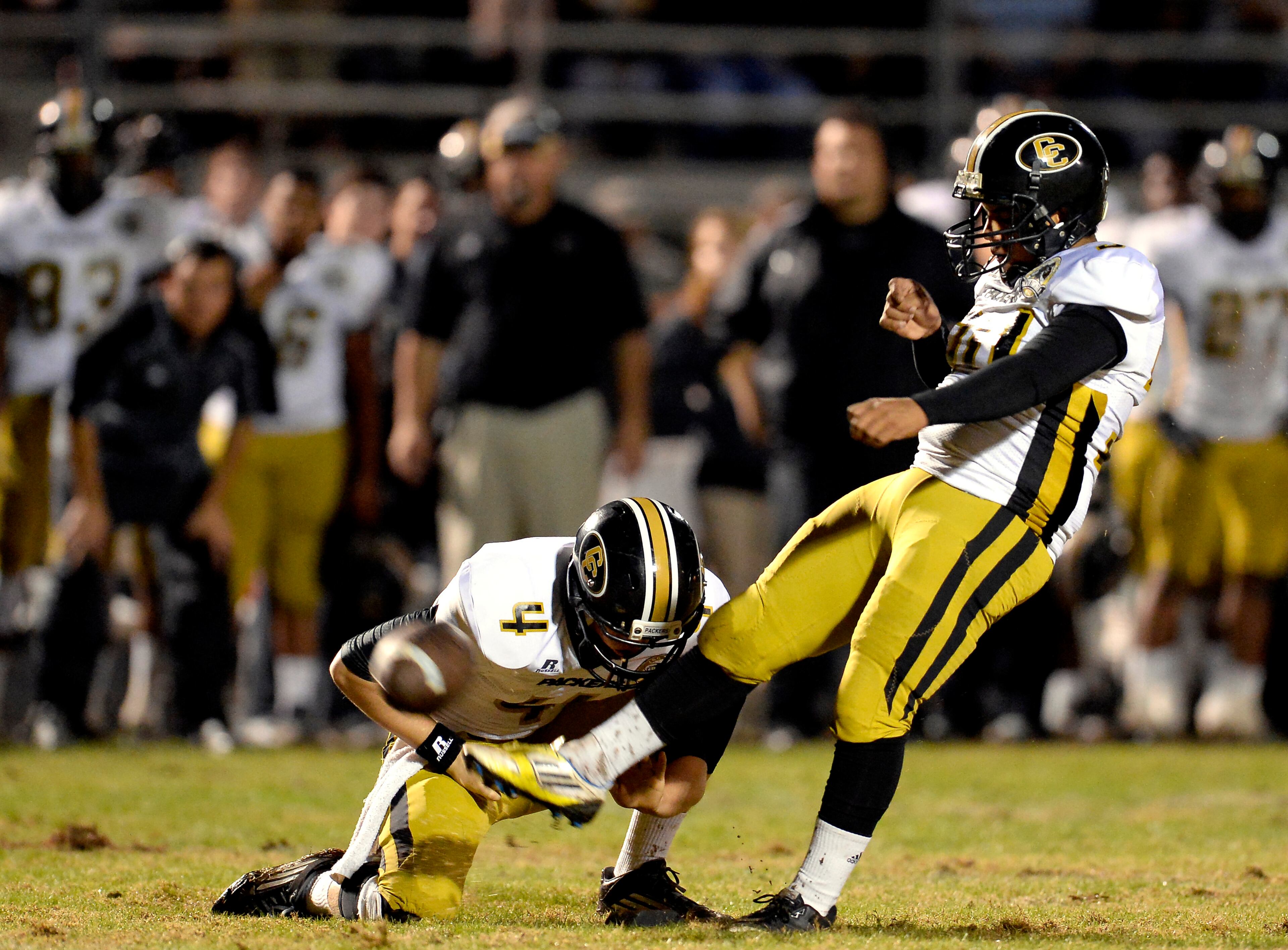 Colquitt County kicker Jose Vega, right, scores the second of his three first half field goals in front of holder Chase Parrish (4) in their AAAAAA semifinal game against Norcross at Blue Devil Stadium on Friday, Dec. 6, 2013, in Norcross, Ga.