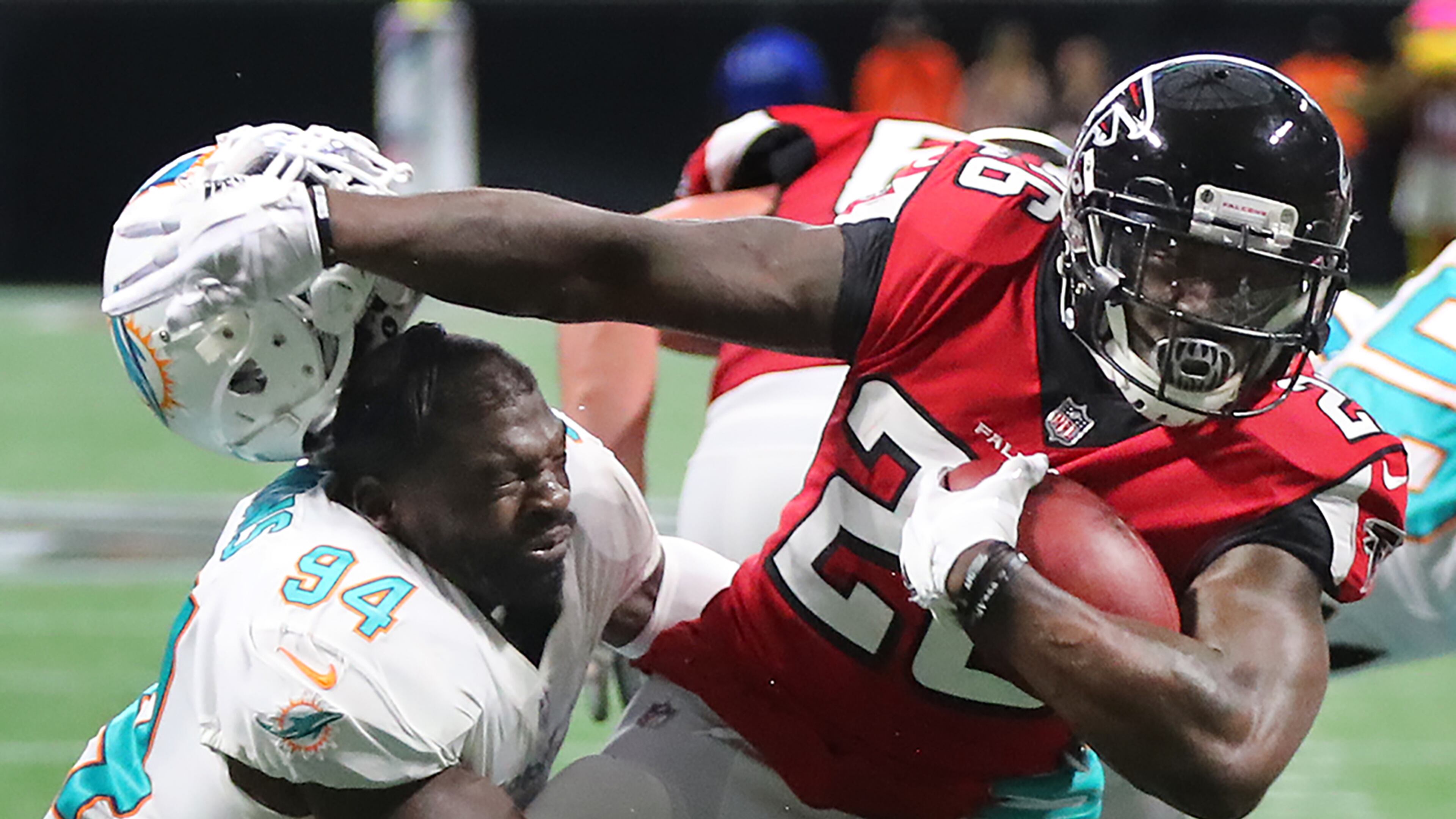 Falcons running back Tevin Coleman separates Miami linebacker Lawrence Timmons from his helmet on the way to a touchdown. (Curtis Compton/ccompton@ajc.com)