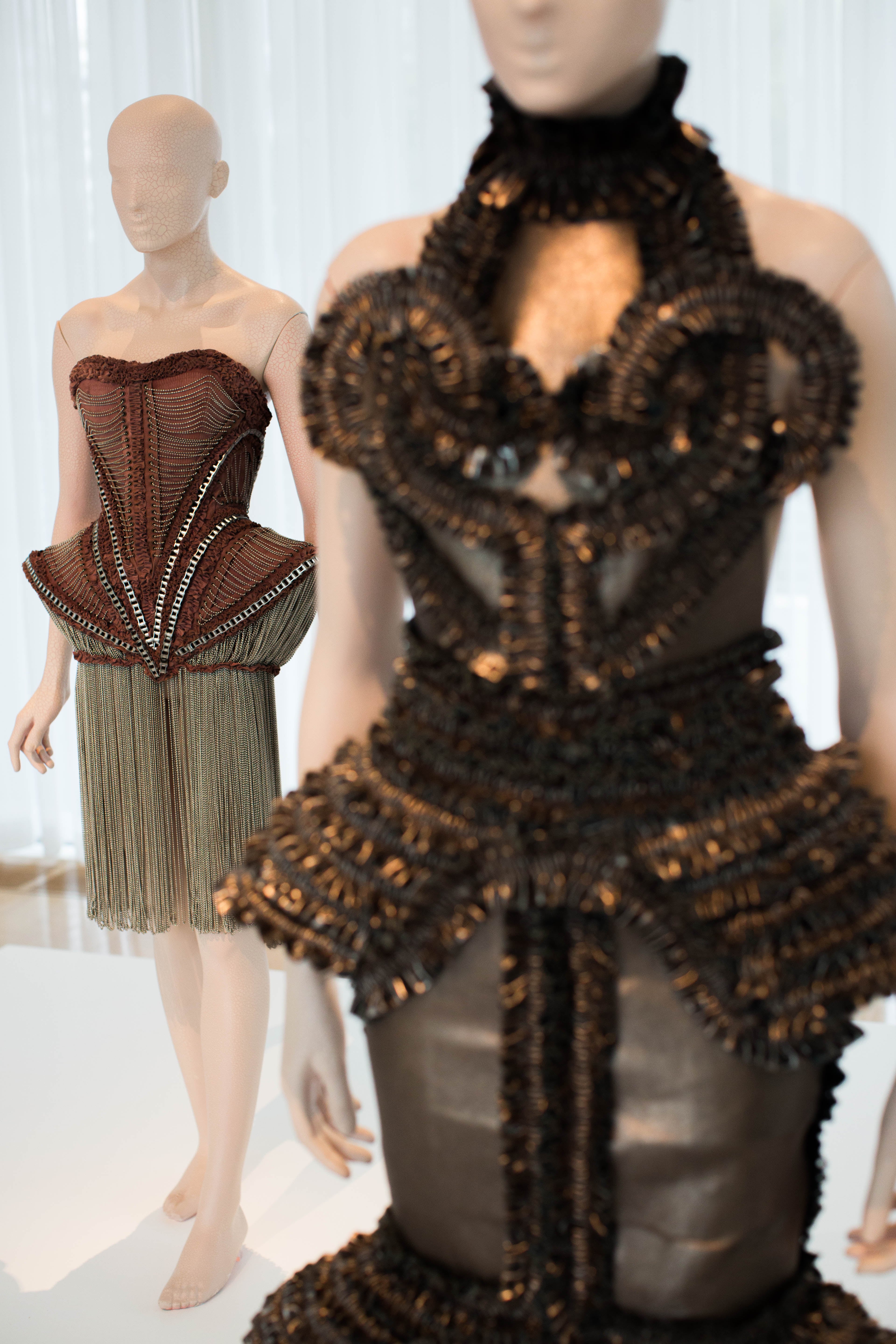 Dresses the from the Mummification collection by designer Iris van Herpen are displayed at the High Museum's new exhibit, "Iris van Herpen: Transforming Fashion," Thursday, Nov. 5, 2015, in Atlanta. The exhibit, running through May 15, shows the evolution of van Herpen's design from collections created from 2008 through 2015. Van Herpen is known for creating high-tech fabrics and fashions that combine materials like steel and silk with everyday objects like magnets and umbrella parts. (AP Photo/Branden Camp)