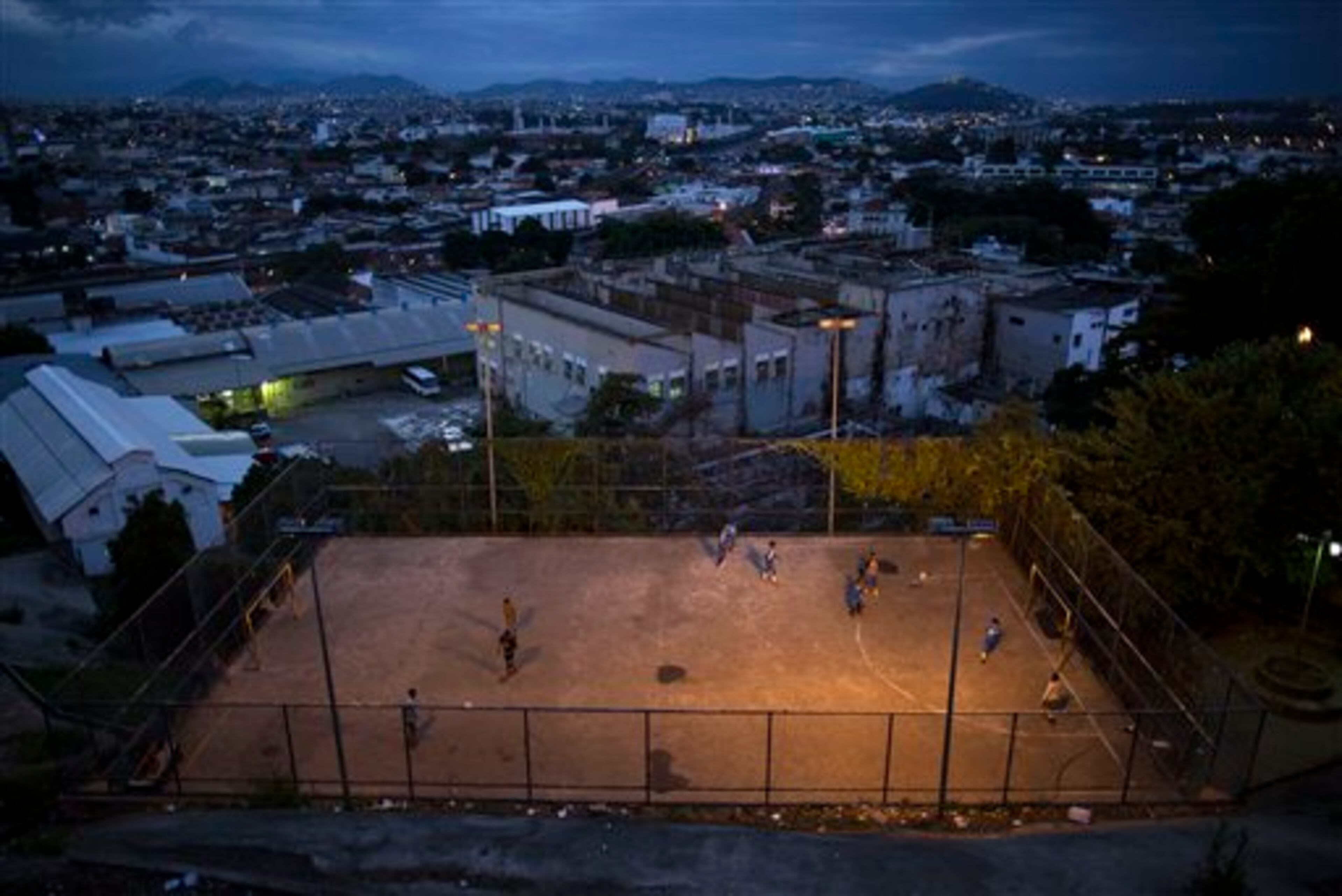 In this Monday, June 2, 2014 photo, youth play soccer in the Mangueira slum of Rio de Janeiro, Brazil. Less than half a kilometer separates the sprawling slum from the Maracana stadium, but residents will be following the World Cup on television due to tickets being so expensive and hard to come by. (AP Photo/Leo Correa)