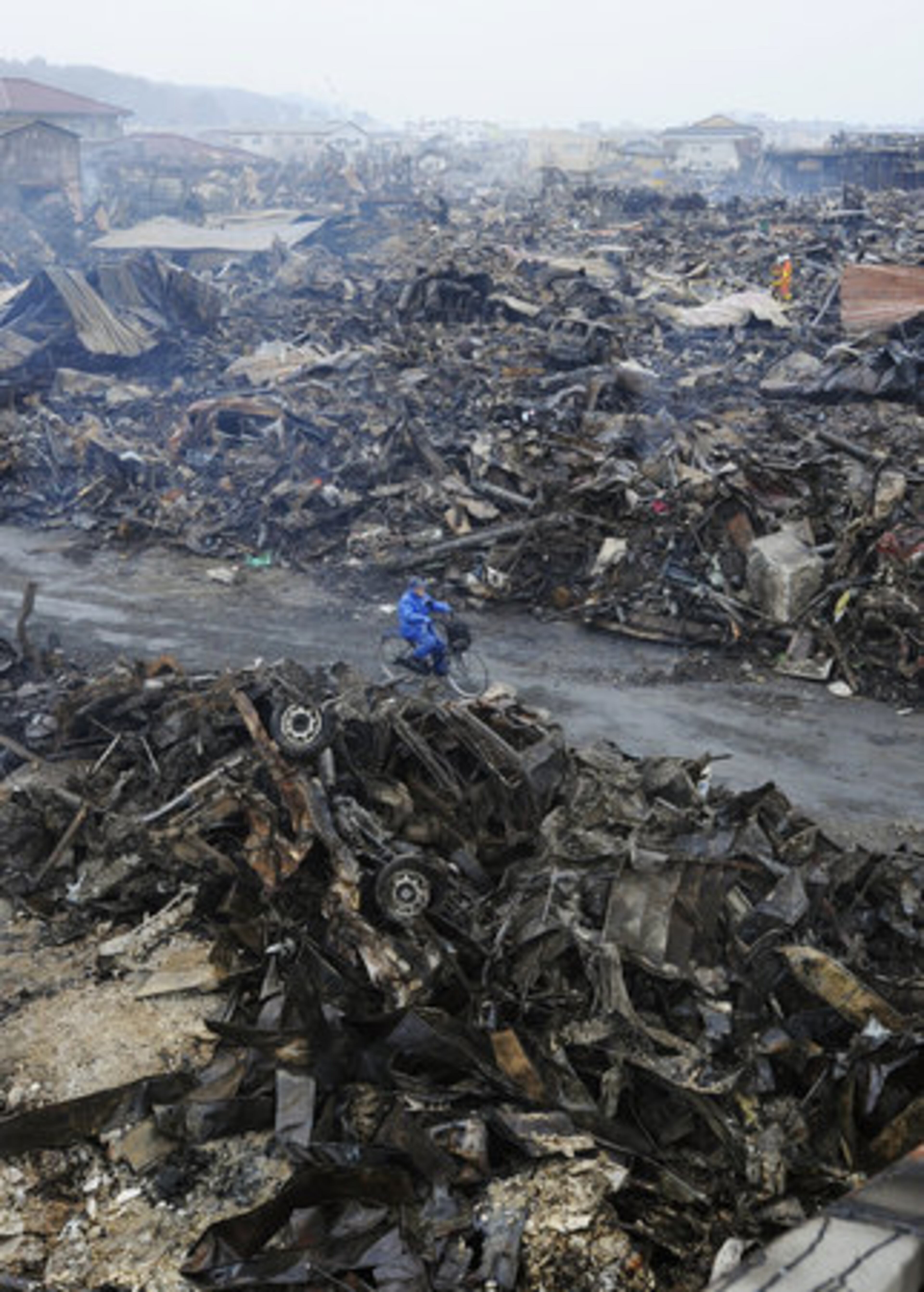 A man rides a bicycle through the rubble in Kesennuma, Miyagi Prefecture, Japan.