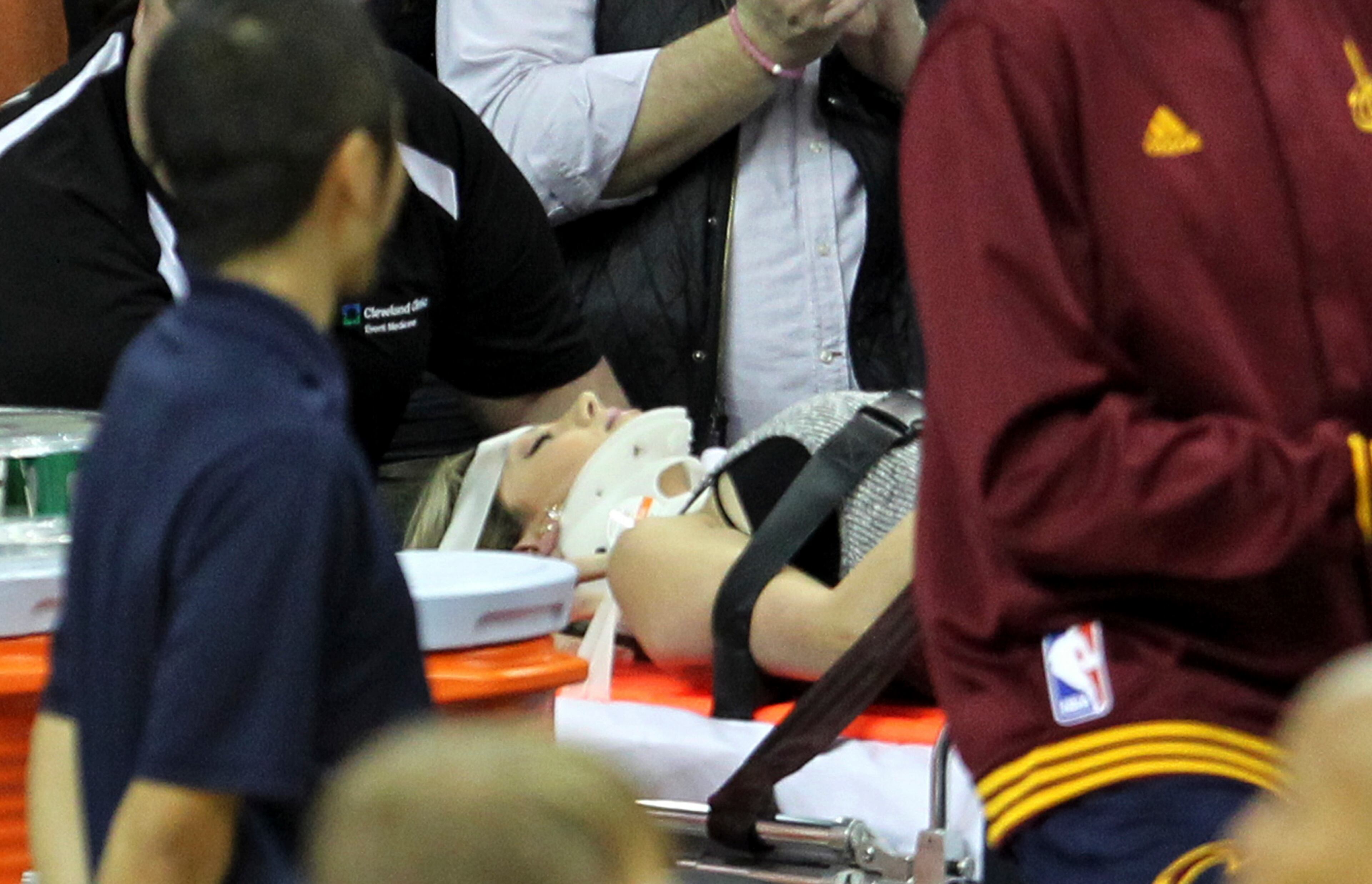 Ellie Day, wife of PGA Tour player Jason Day, is carried off the floor in a stretcher after Cleveland Cavaliers' 6-foot-8, 250-pound LeBron James collided with her out of bounds in the second half of an NBA basketball game against the Oklahoma City Thunder, Thursday, Dec. 17, 2015, in Cleveland. Ellie Day was suffering concussion symptoms Friday. (John Kuntz/The Plain Dealer via AP)