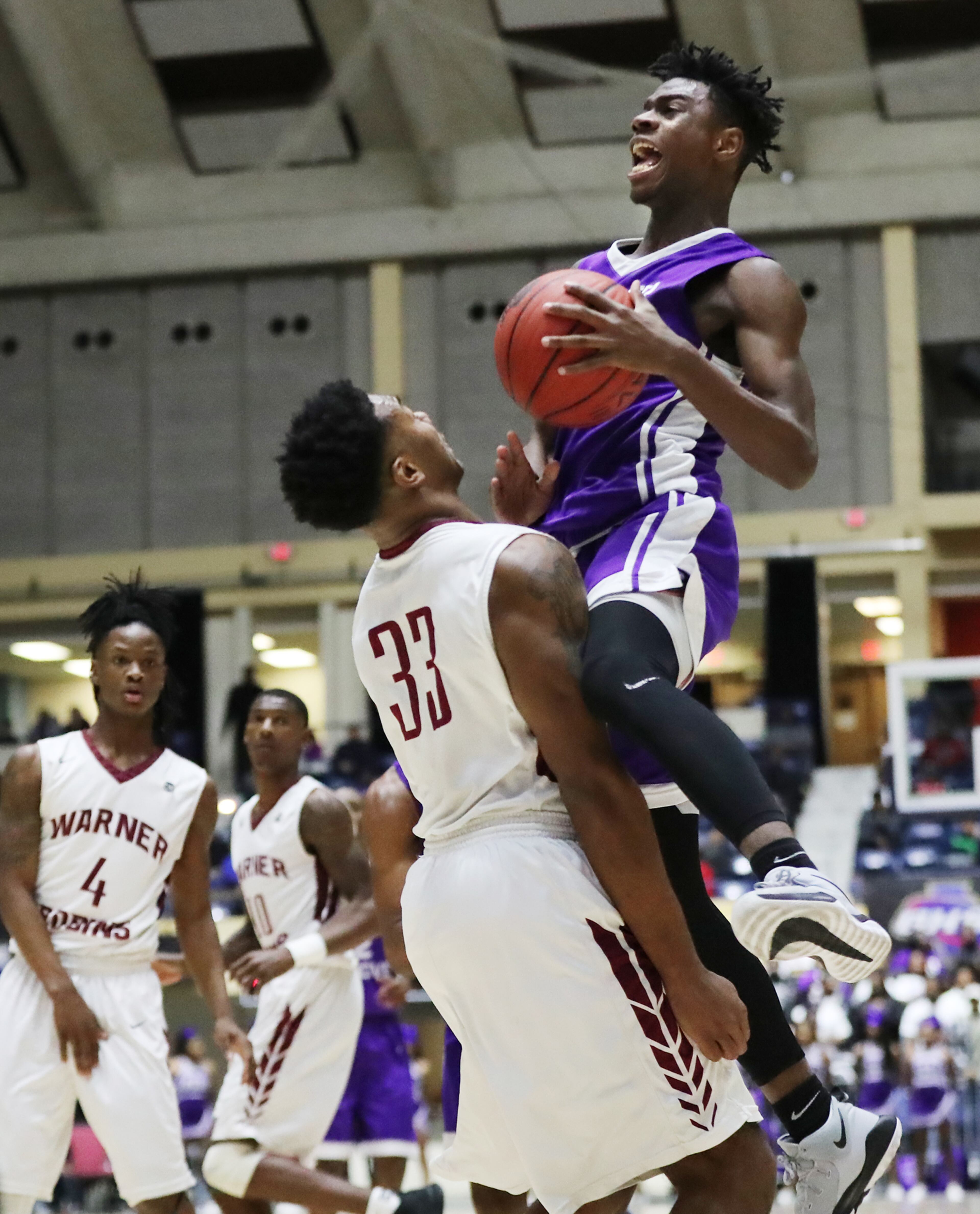 March 8, 2018 Macon: Miller Grove guard Maurice Harvey draws a foul from Warner Robins defender Jamâl Dillard on his way to the basket in their GHSA state basketball championship game on Thursday, March 8, 2018, in Macon. Curtis Compton/ccompton@ajc.com