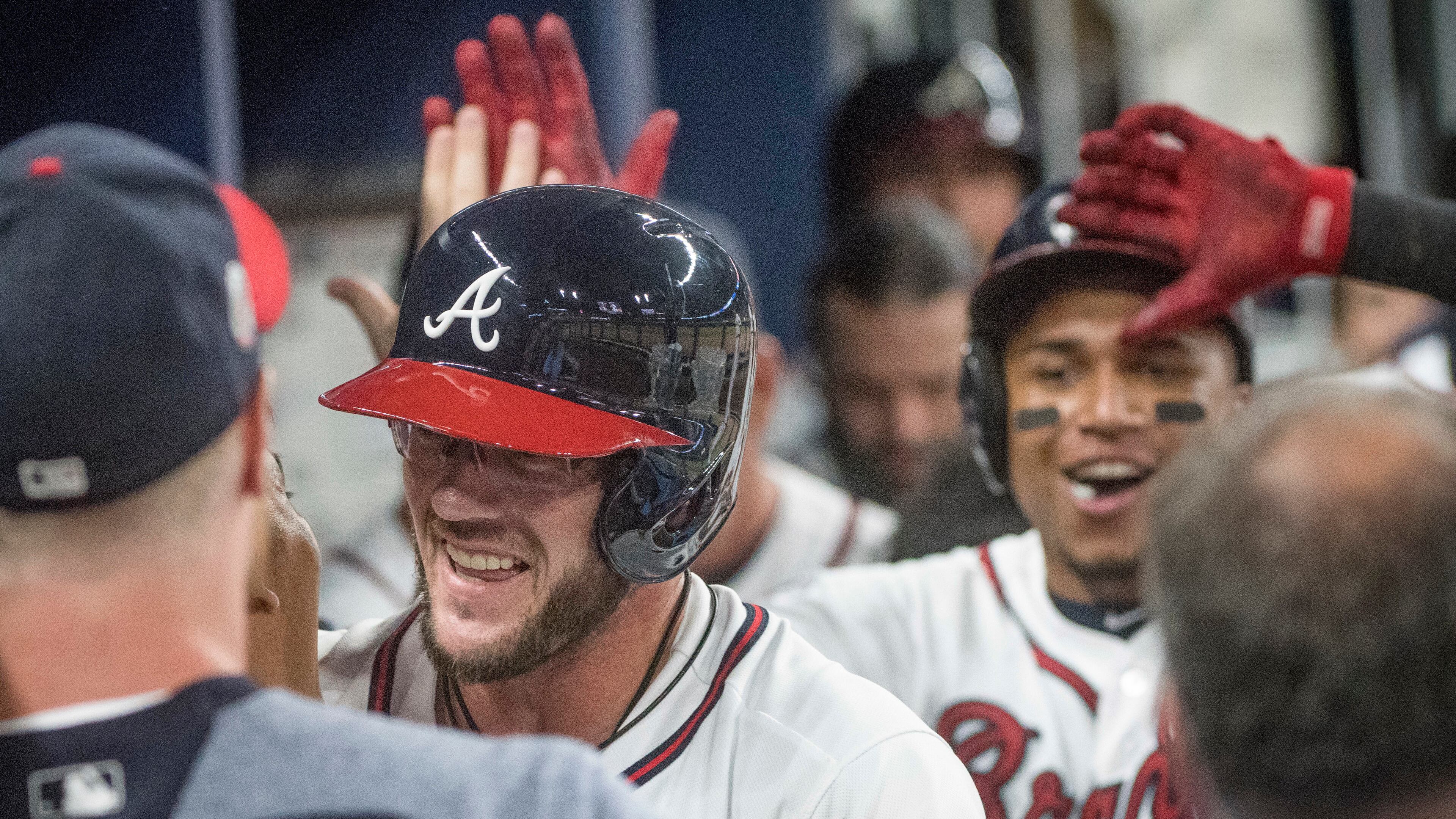 Braves’ Tyler Flowers, second from left, is followed into the dugout by Johan Camargo as they celebrate Flowers’ two-run home run during the eighth inning. (AP Photo/John Amis)