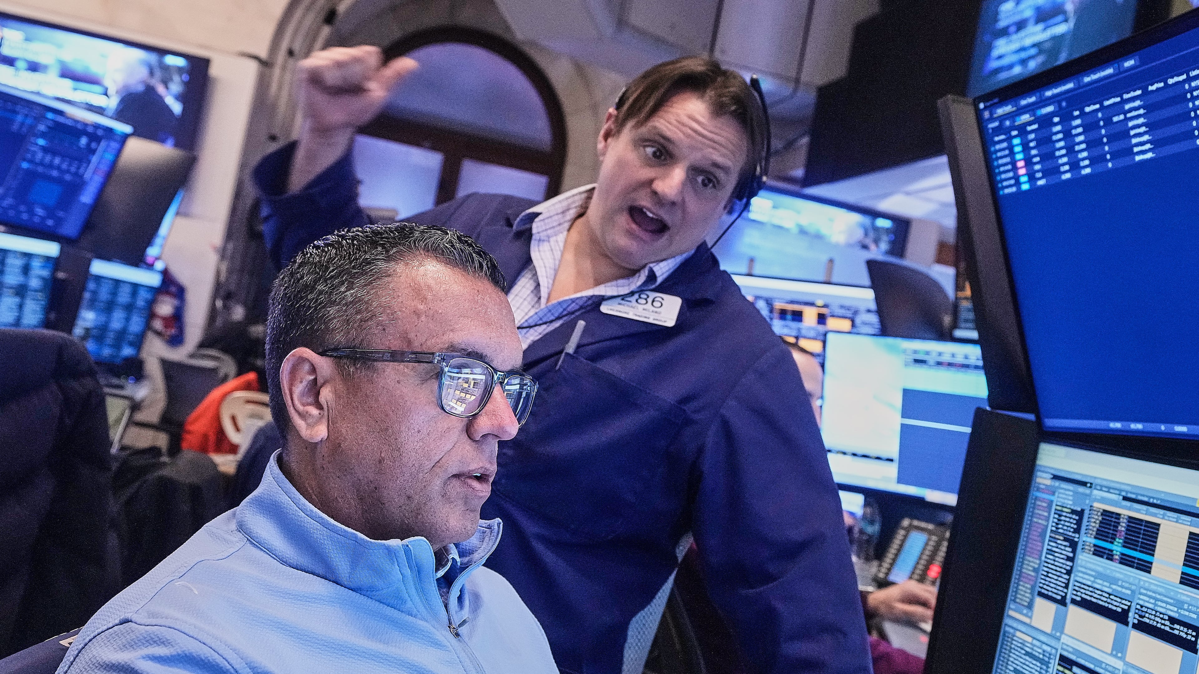 Traders Robert Finnerty Jr., foreground, and Michael Milano work on the floor of the New York Stock Exchange, Monday, Jan. 26, 2026. (AP Photo/Richard Drew)
