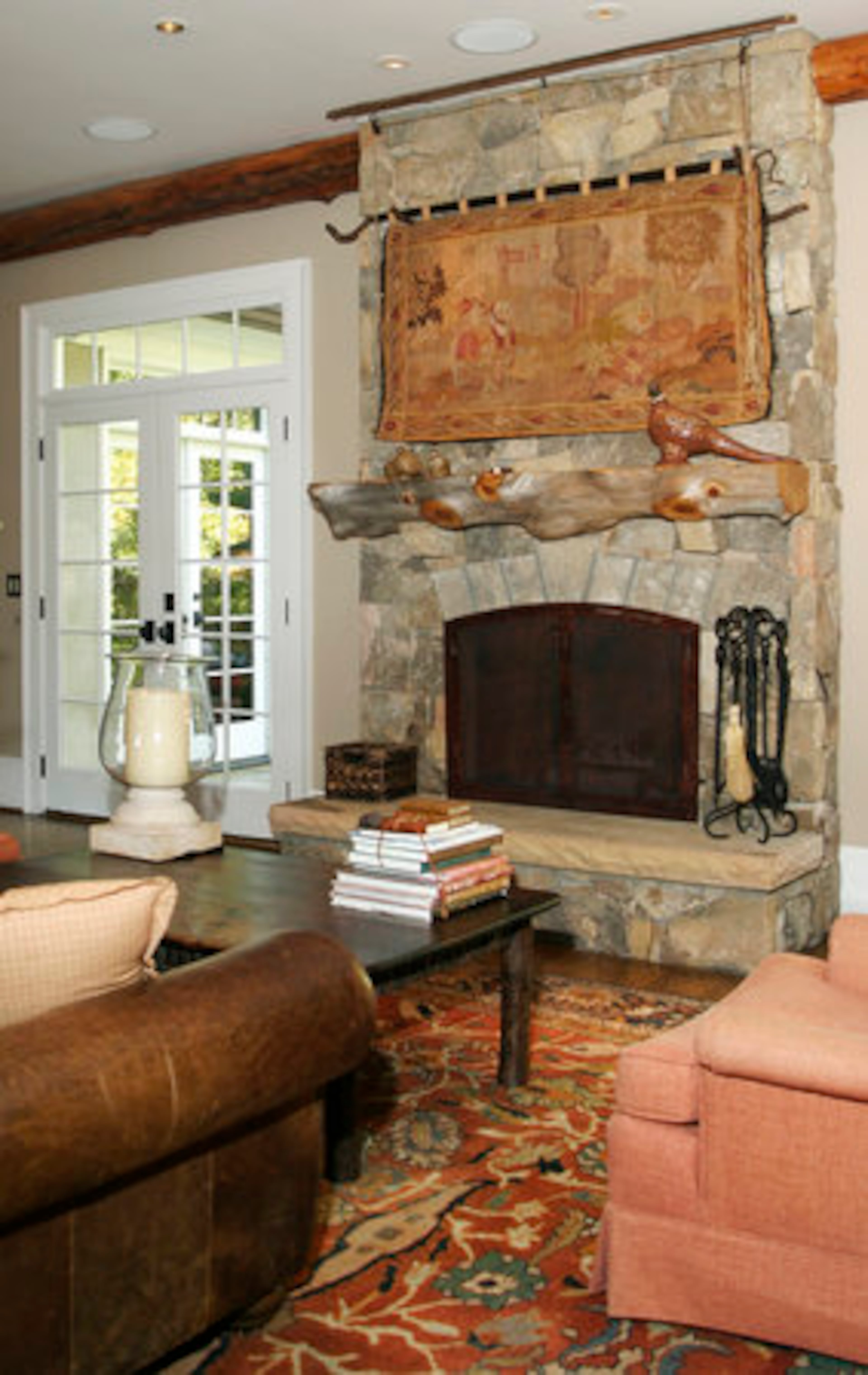 The fireplace is made of Tennessee Fieldstone and has a unique tapestry that conceals the flat-screen TV.