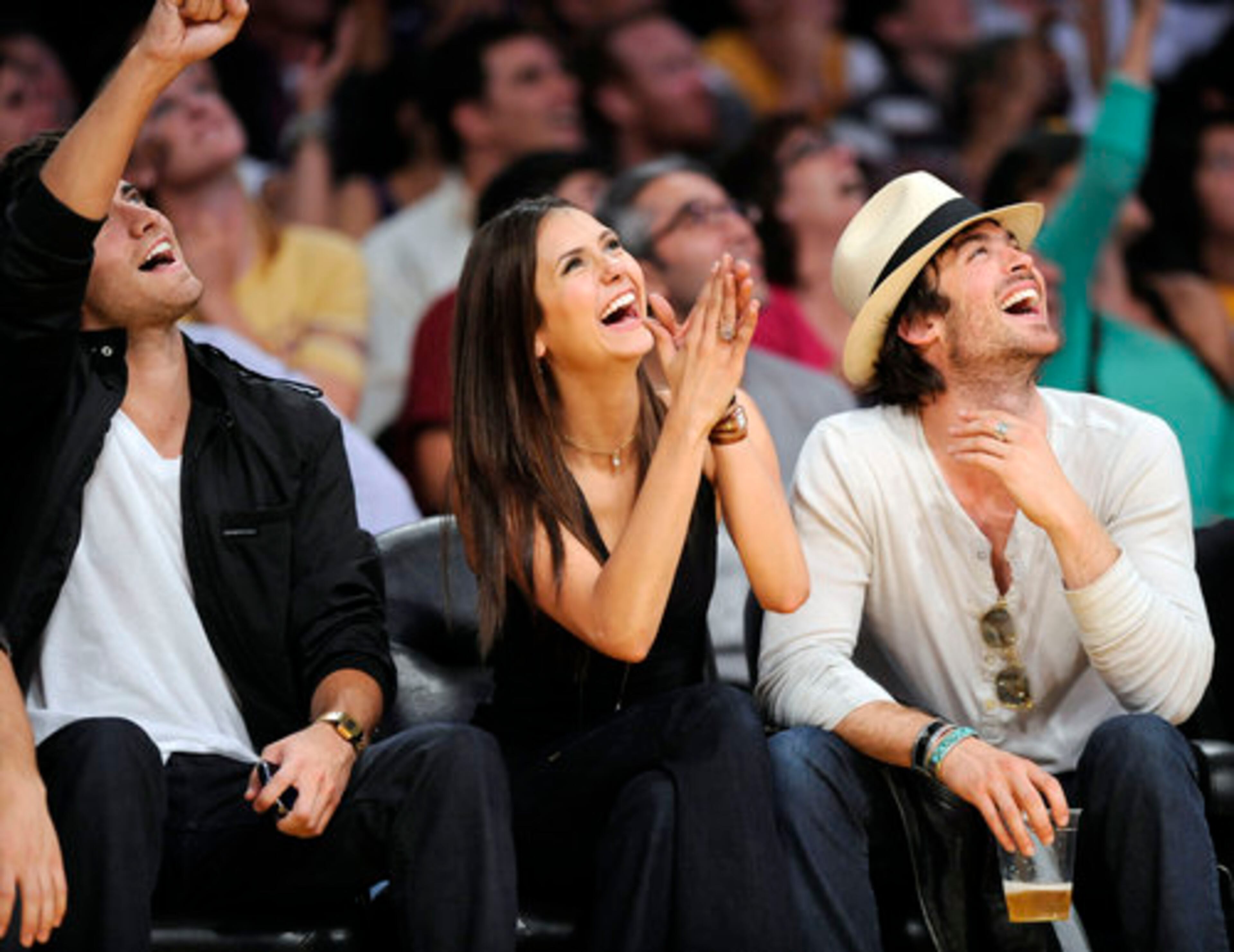 Elena Dobrev, center, Ian Somerhalder, right, and Paul Wesley, stars of the television show "The Vampire Diaries, " react during the second half of Game 5 of the NBA basketball Western Conference finals between the Los Angeles Lakers and the Phoenix Suns.