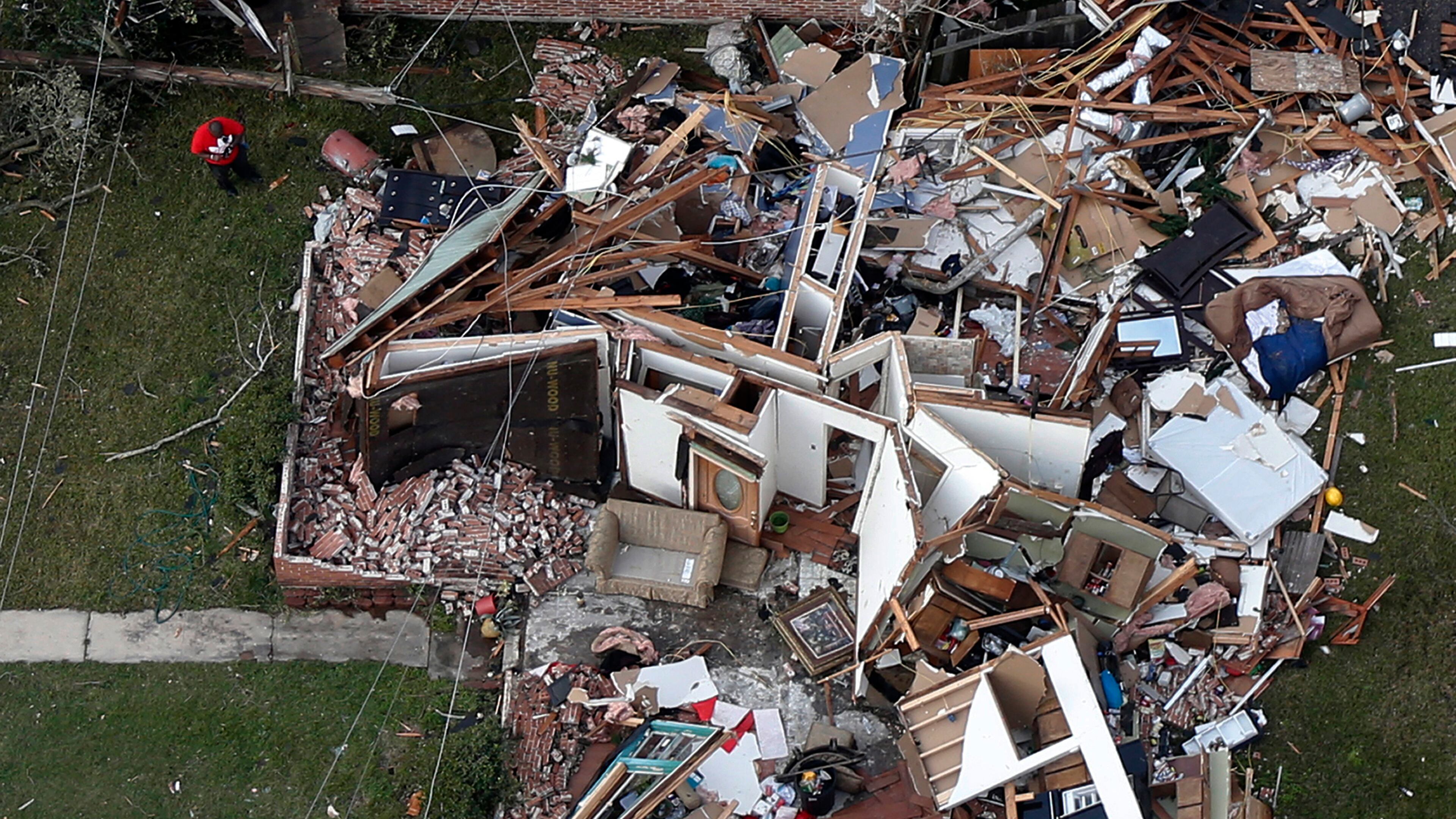 A man stands next to a destroyed home after a tornado tore through the eastern neighborhood of New Orleans, Tuesday, Feb. 7, 2017. Louisiana Gov. John Bel Edwards took an aerial tour before meeting New Orleans officials. He says the path of destruction is wide and varied. In eastern New Orleans, he says "it kind of bounced back and forth" across the busy Chef Menteur Highway. (AP Photo/Gerald Herbert)