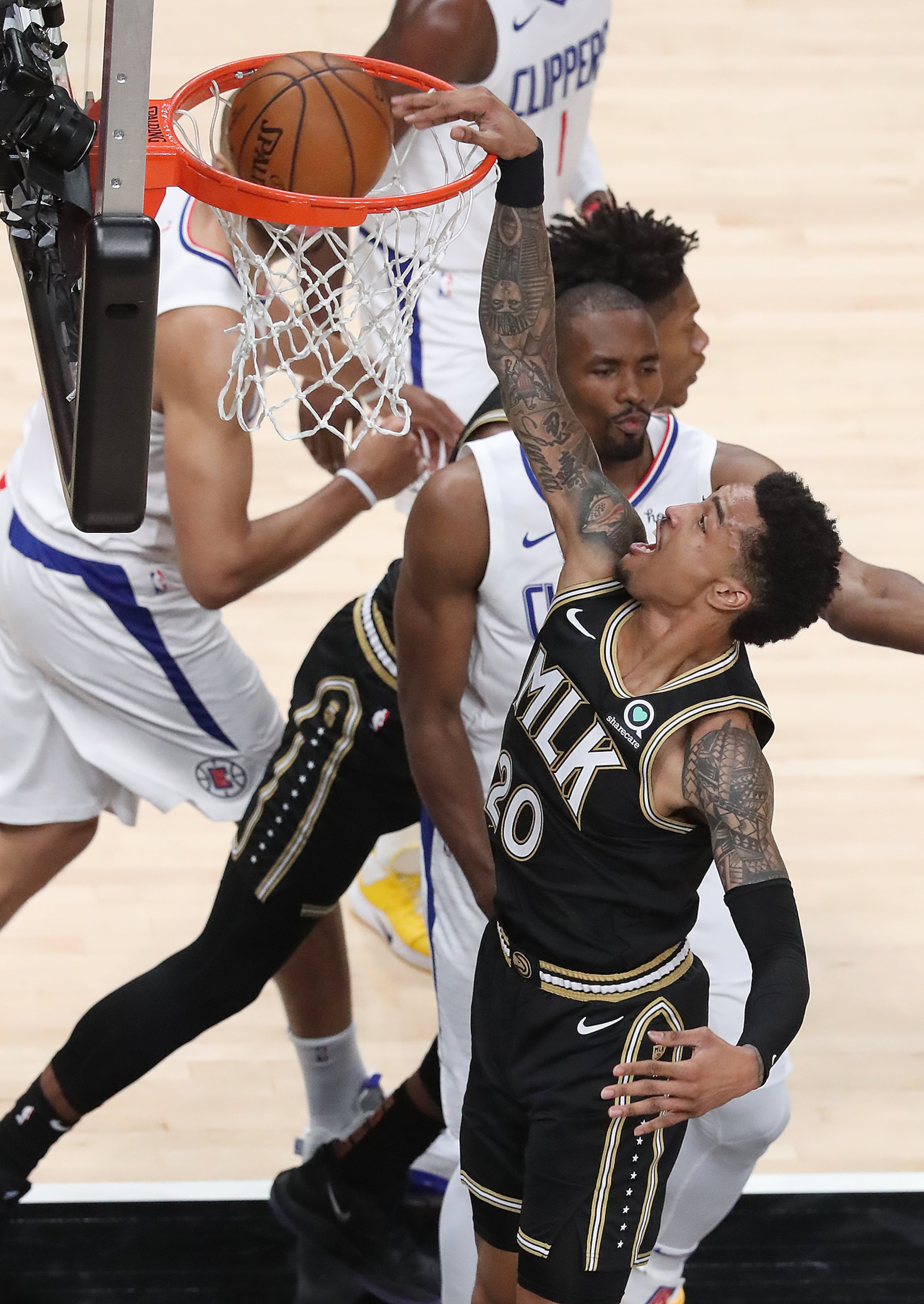 Hawks' John Collins slams for two against the Los Angeles Clippers in an NBA basketball game on Tuesday, Jan. 26, 2021, in Atlanta. Curtis Compton / Curtis.Compton@ajc.com”