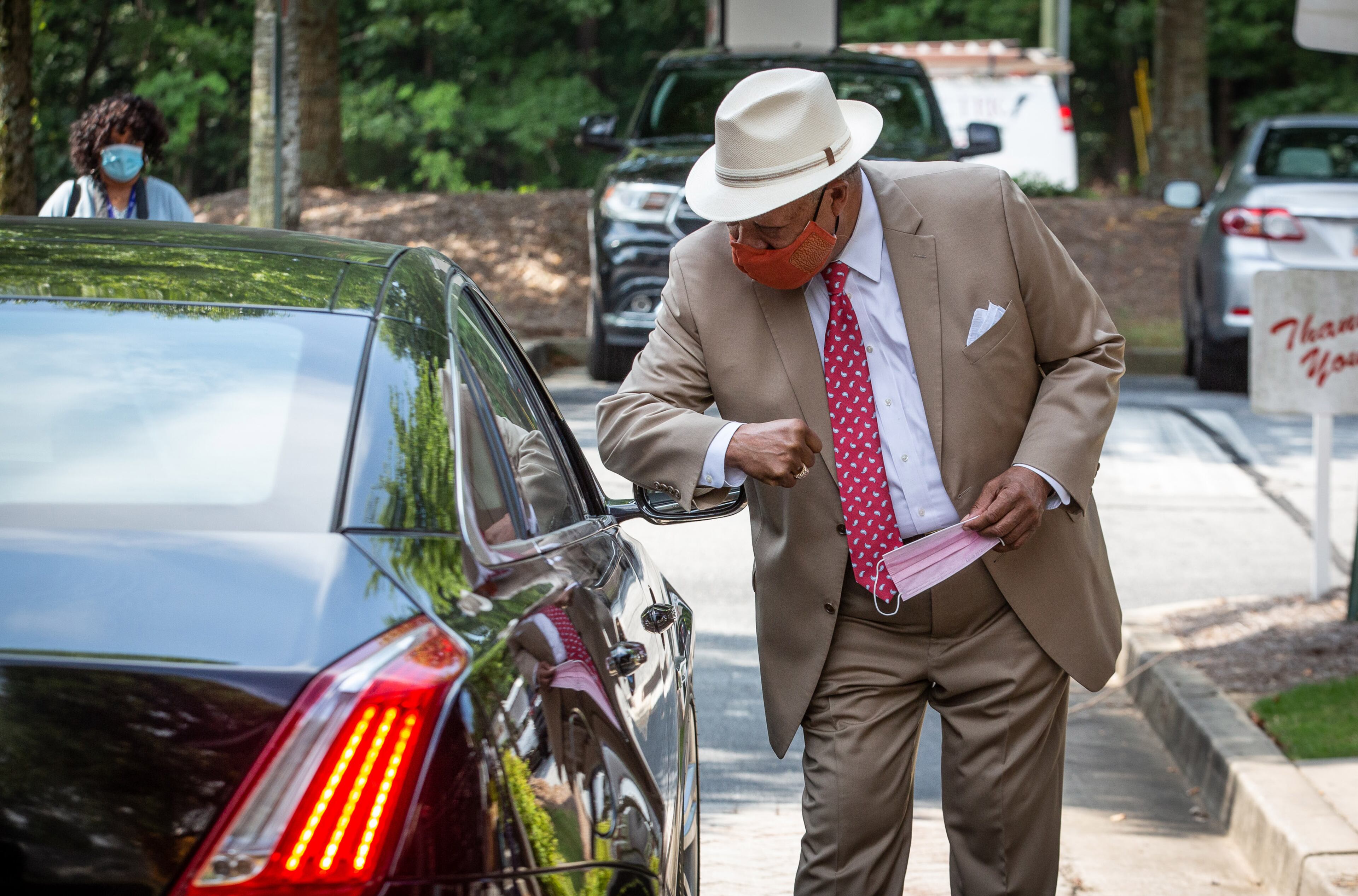 Fulton County Commissioner Robb Pitts gives an elbow bump to a passenger in a car while distributing PPE to businesses in Atlanta, August 6, 2020. STEVE SCHAEFER FOR THE ATLANTA JOURNAL-CONSTITUTION