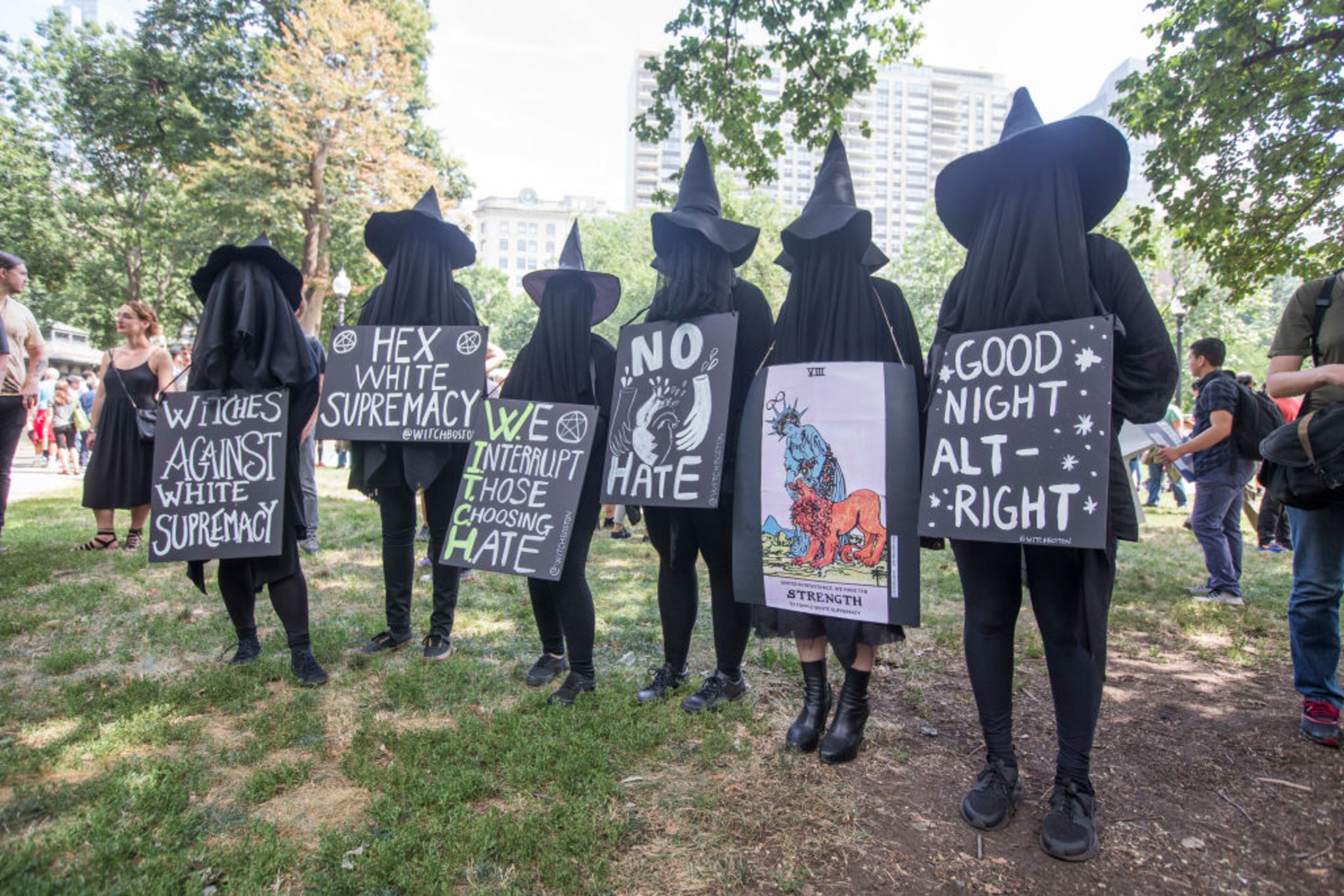 BOSTON, MA - AUGUST 19: Counter protesters in witch costumes hold up signs after a march to the 'Free Speech Rally' on Boston Common on August 19, 2017 in Boston, Massachusetts. Thousands of demonstrators and counter-protestors are expected at Boston Common where the Boston Free Speech Rally is being held. (Photo by Scott Eisen/Getty Images)