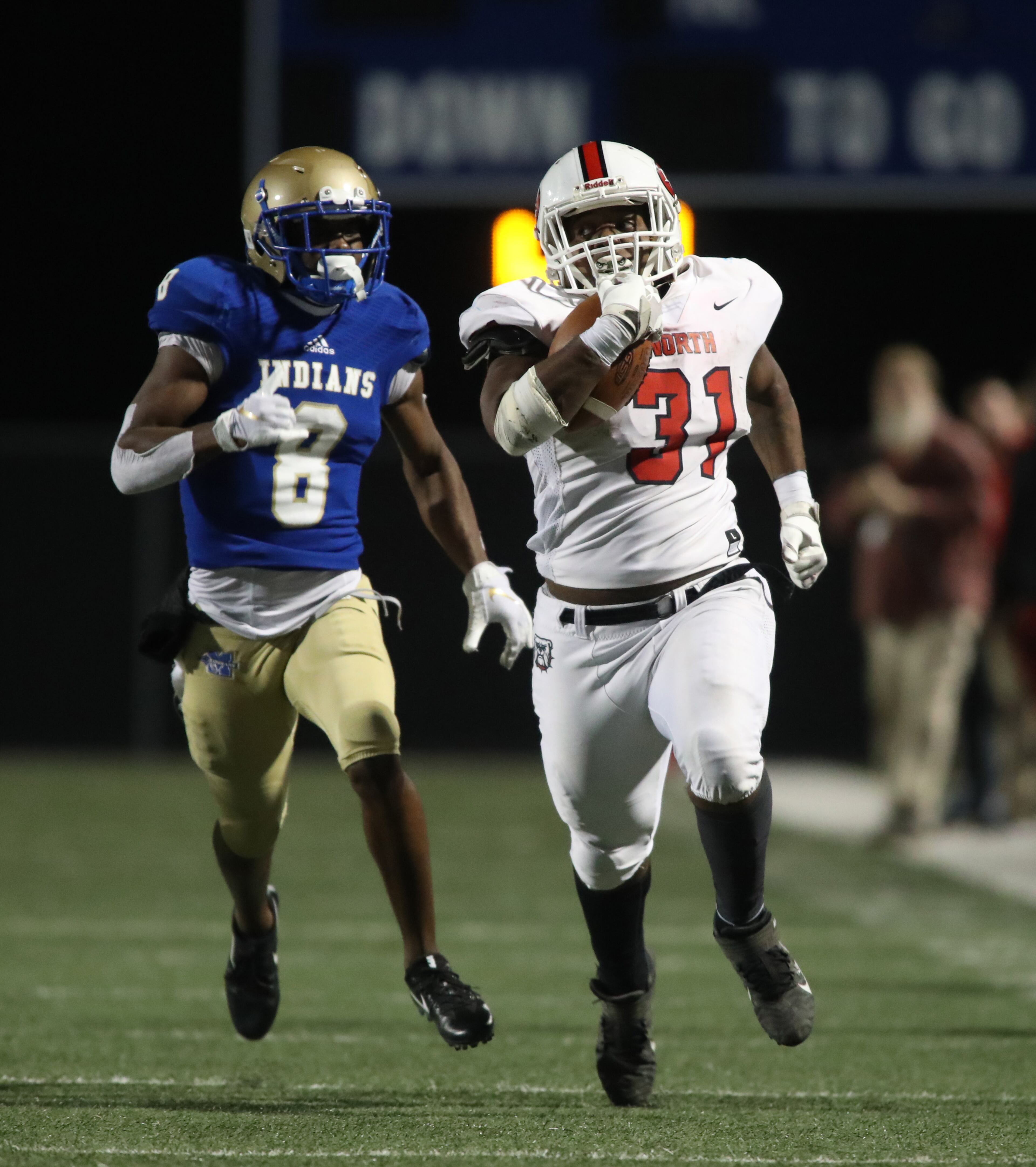 North Gwinnett running back Devin Crosby (31) runs for yards against McEachern defensive back Kevon Angry (8) in the second half of the Class 7A quarterfinals at McEachern High School Friday, November 29, 2019 in Powder Springs, Ga. North Gwinnett won 32-13. (JASON GETZ/SPECIAL TO THE AJC)
