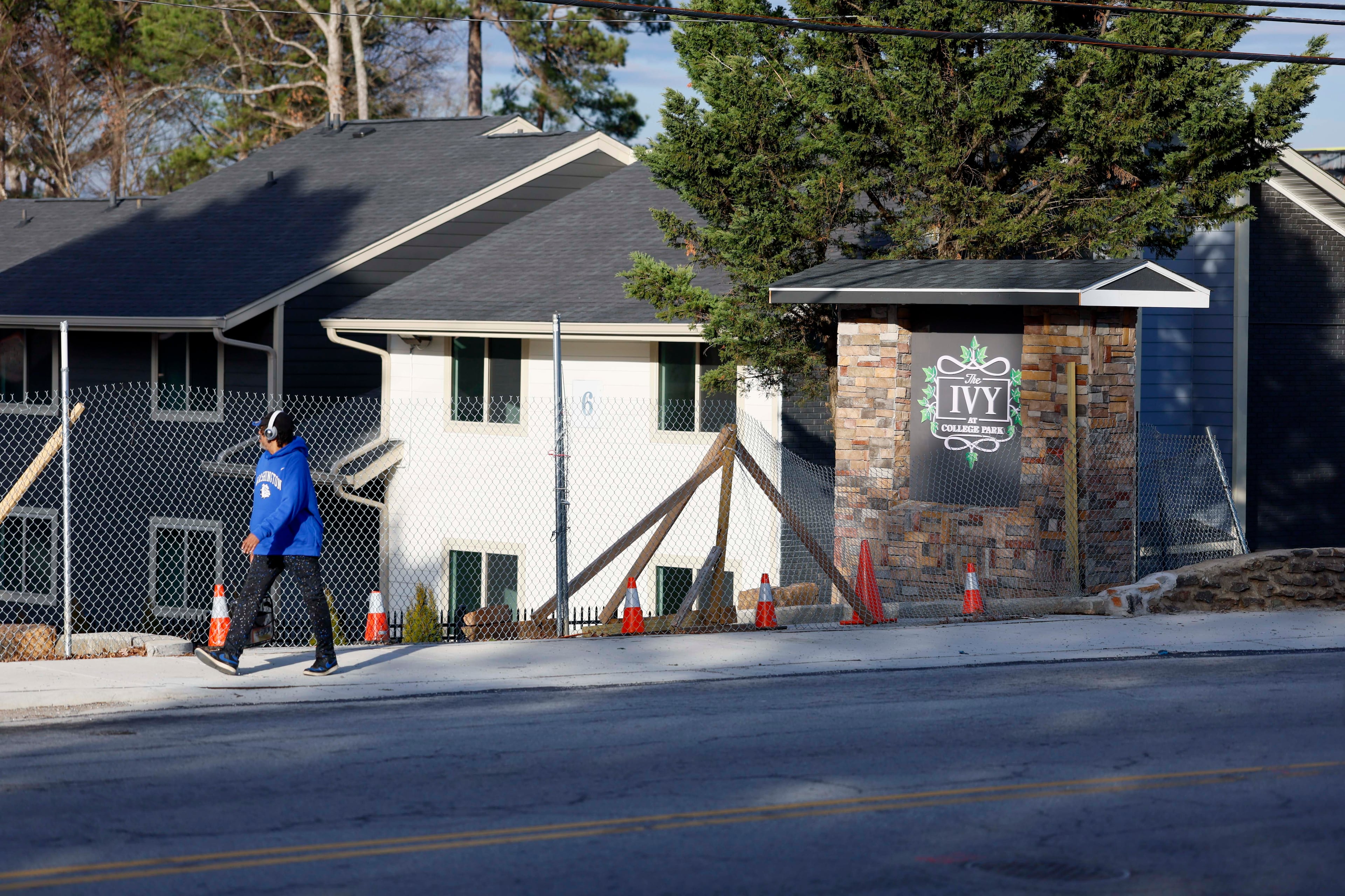 A pedestrian walks past the main entrance to the Ivy at College Park, formerly called Chelsea Gardens, on Tuesday, Feb. 3, 2026. (Miguel Martinez/AJC)