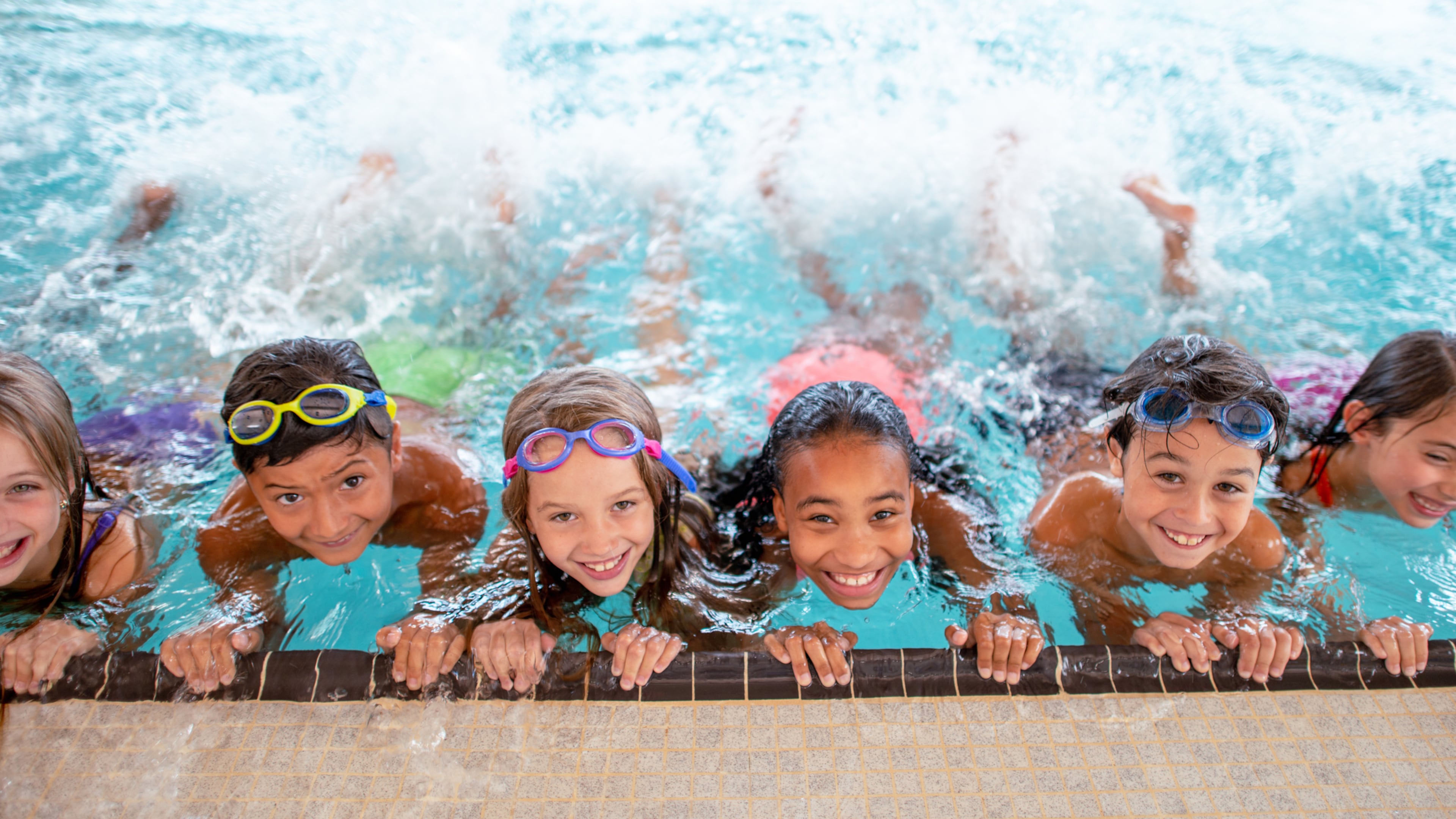 Group of elementary age children at in the pool during swimming class.