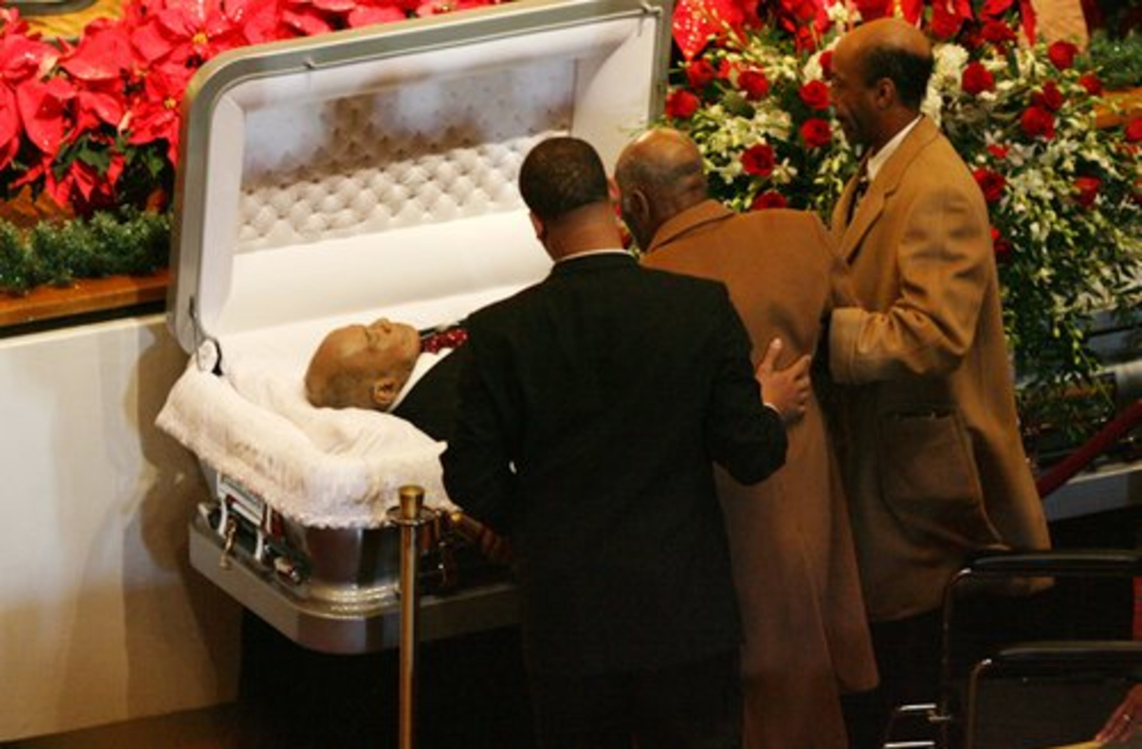 Roswell Sutton, Vice President of Paschal's Concessions Inc., views James Vaughn Paschal's body during the funeral.