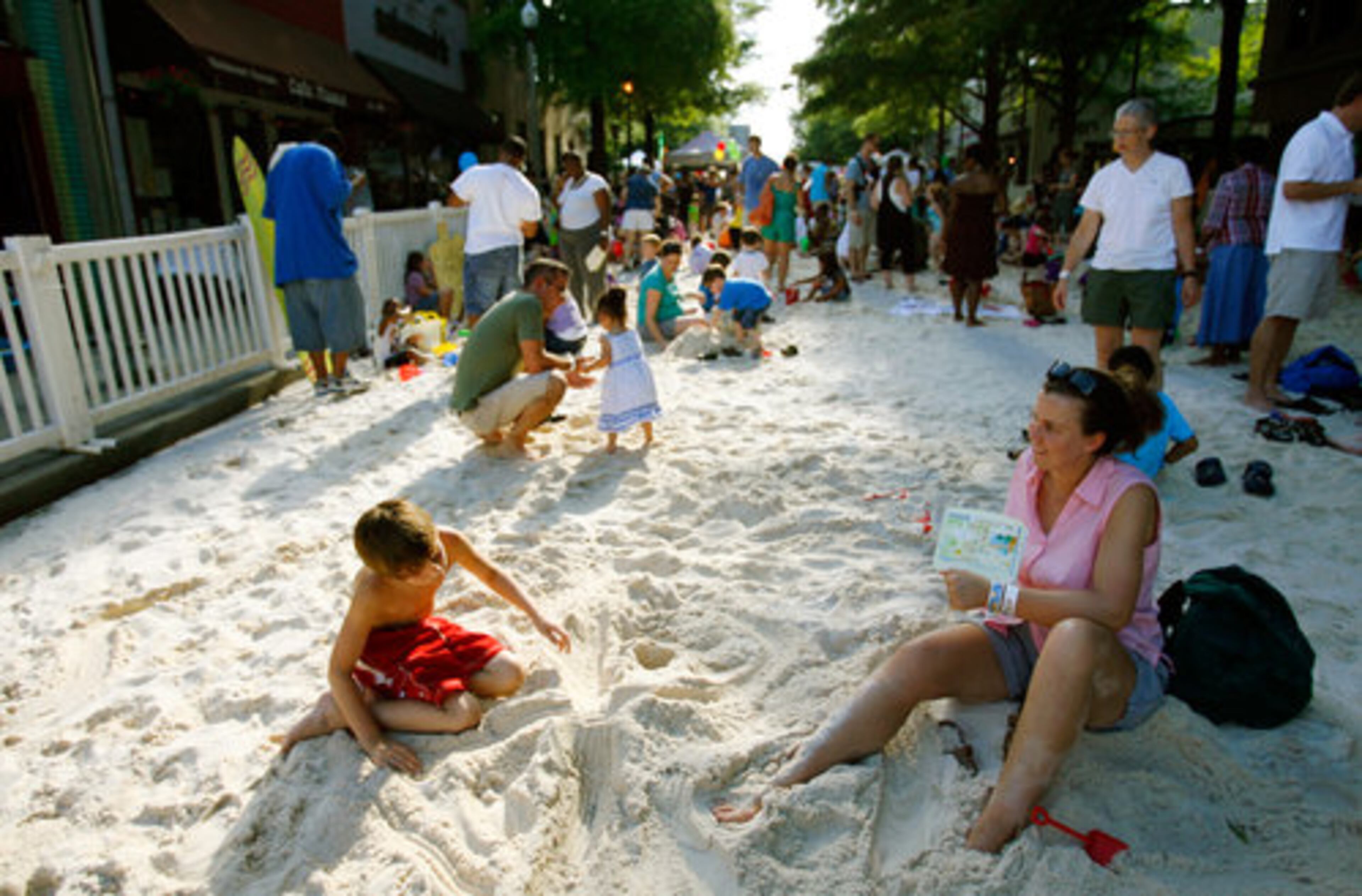 Meghan Egger (right) and her son Jack, 8, of Decatur play in the "beach." The city of Decatuor hauled in 60 tons of sand to create the beach area, which swarmed with parents and their children.