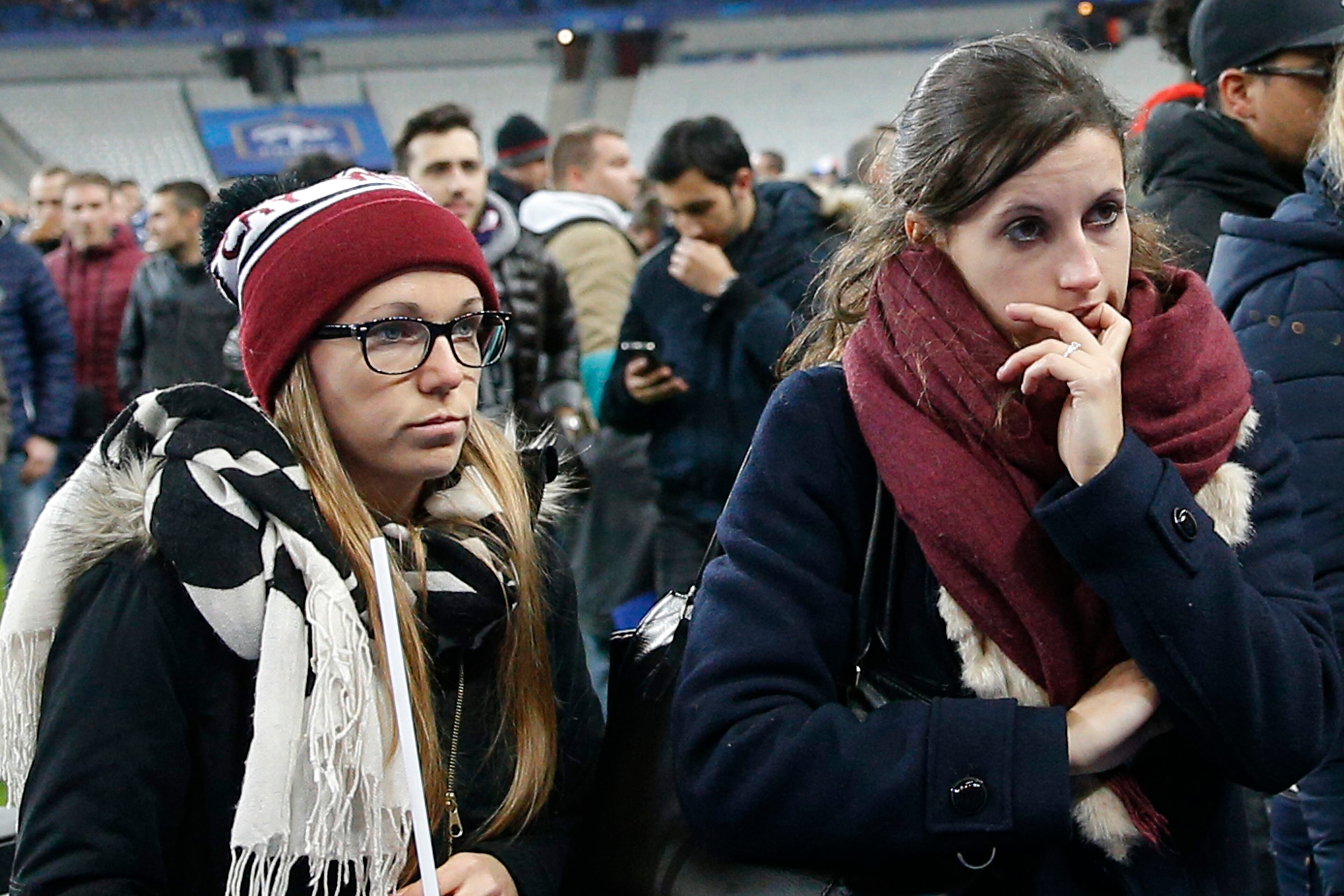 Soccer fans wait on the fitch of the Stade de France stadium after an international friendly soccer match in Saint Denis, outside Paris, Friday, Nov. 13, 2015. An explosion occurred outside the stadium. Several dozen people were killed in a series of unprecedented attacks around Paris on Friday, French President Francois Hollande said, announcing that he was closing the country's borders and declaring a state of emergency. (AP Photo/Christophe Ena)