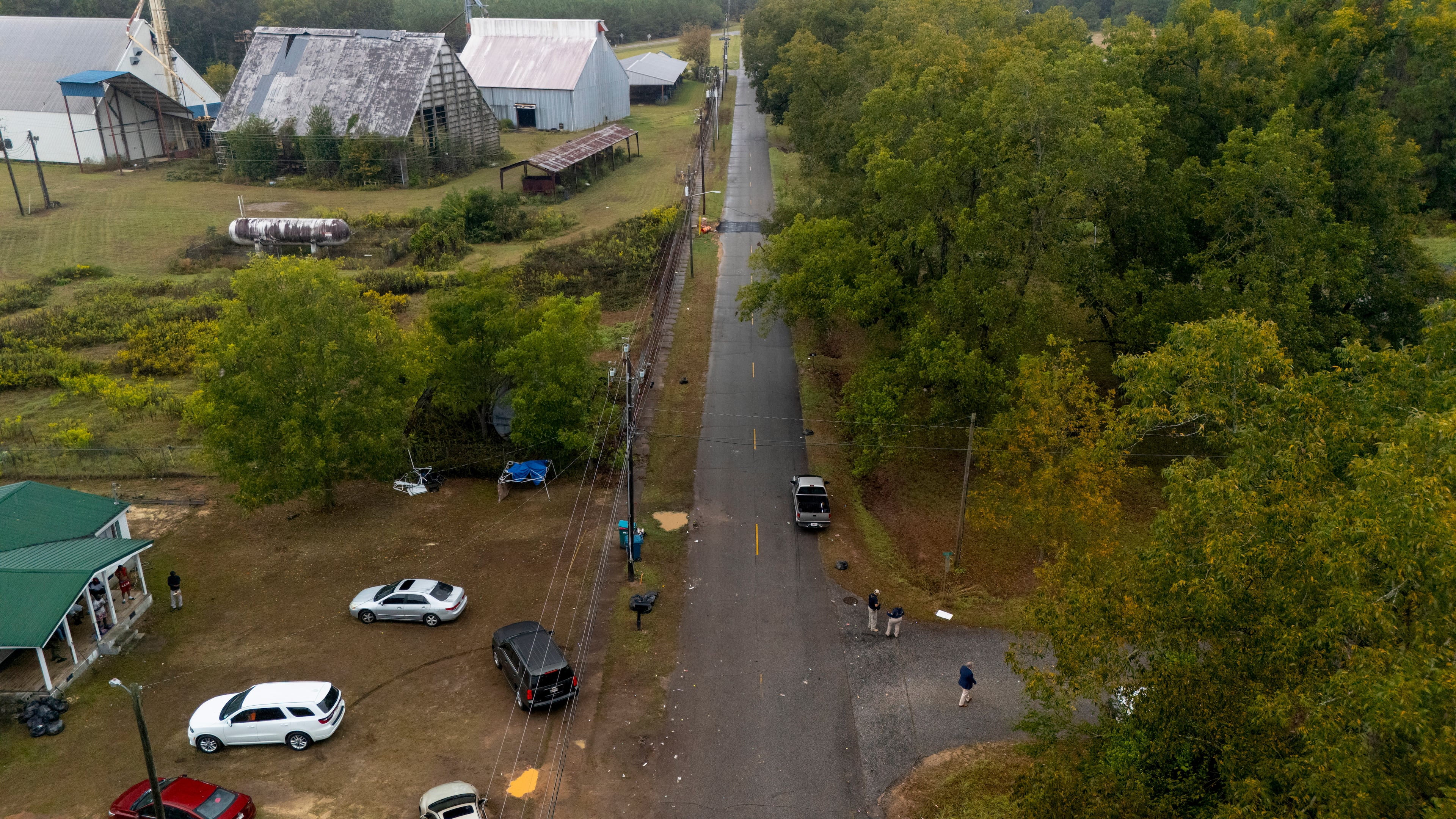 Authorities, below to the right, investigate the scene of a mass shooting where at least two people died and 35 were injured when struck by bullets Sunday morning, according to the Georgia Bureau of Investigation, Sunday, Oct. 4, 2026, in Vienna, Ga. (AP Photo/Mike Stewart)