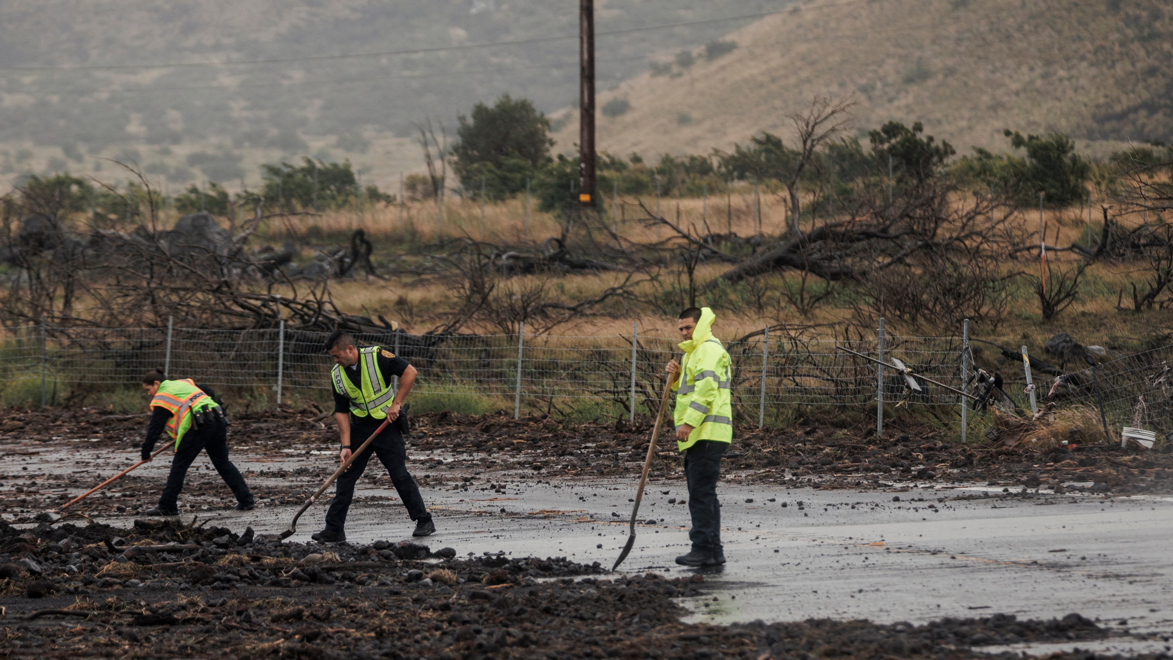Police remove debris strewn across Daniel K. Inouye Highway by Hurricane Lala near Waimea, Hawaii, Sunday, Aug. 16, 2026. (Stephen Lam/San Francisco Chronicle via AP)