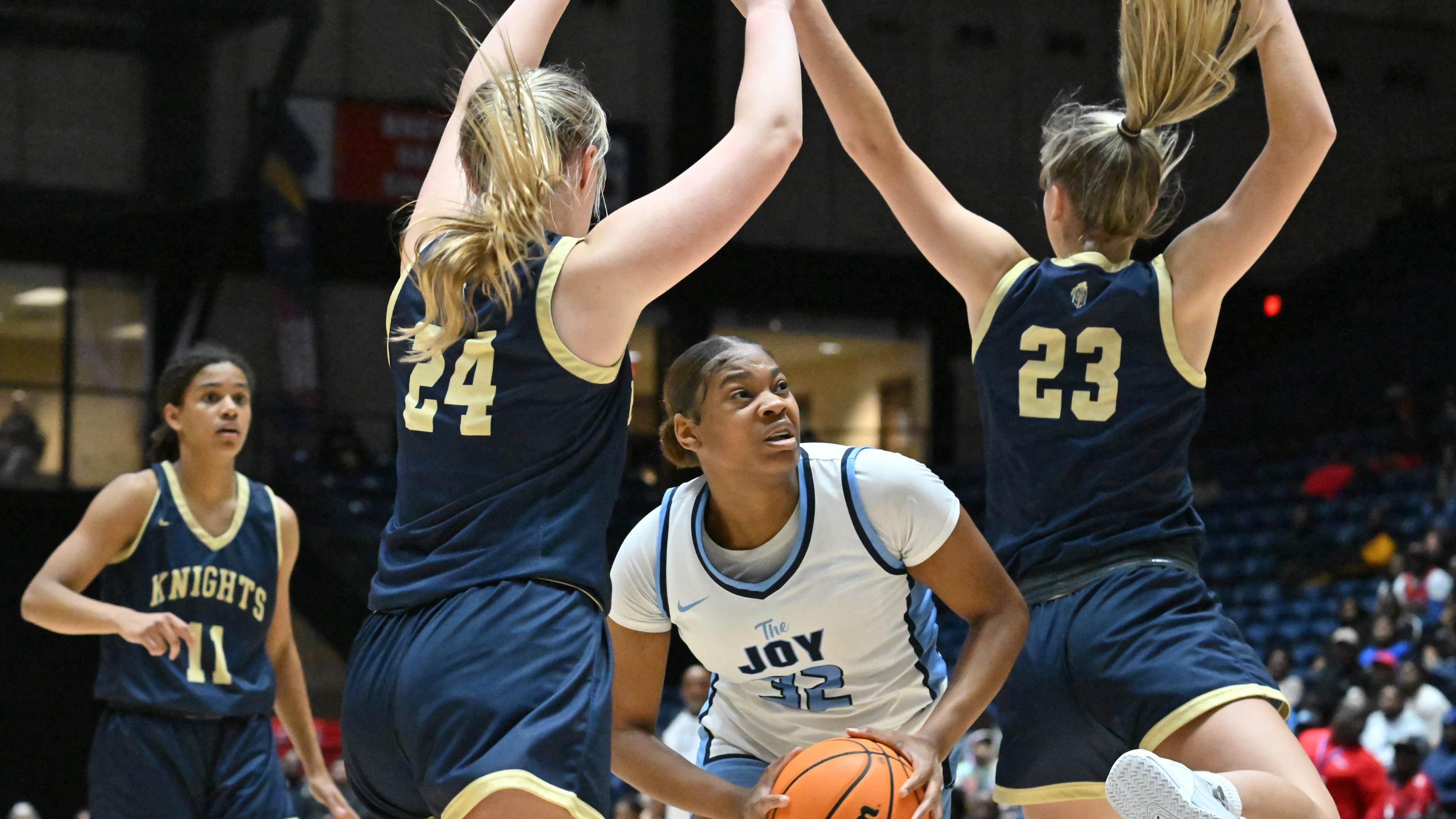 Lovejoy's Jahilya Mcdonald (12) avoids the defensie of Kayla Cleveland (left) and Allie Sweet of River Ridge during the Class 6A girls state championship game Friday in Macon.