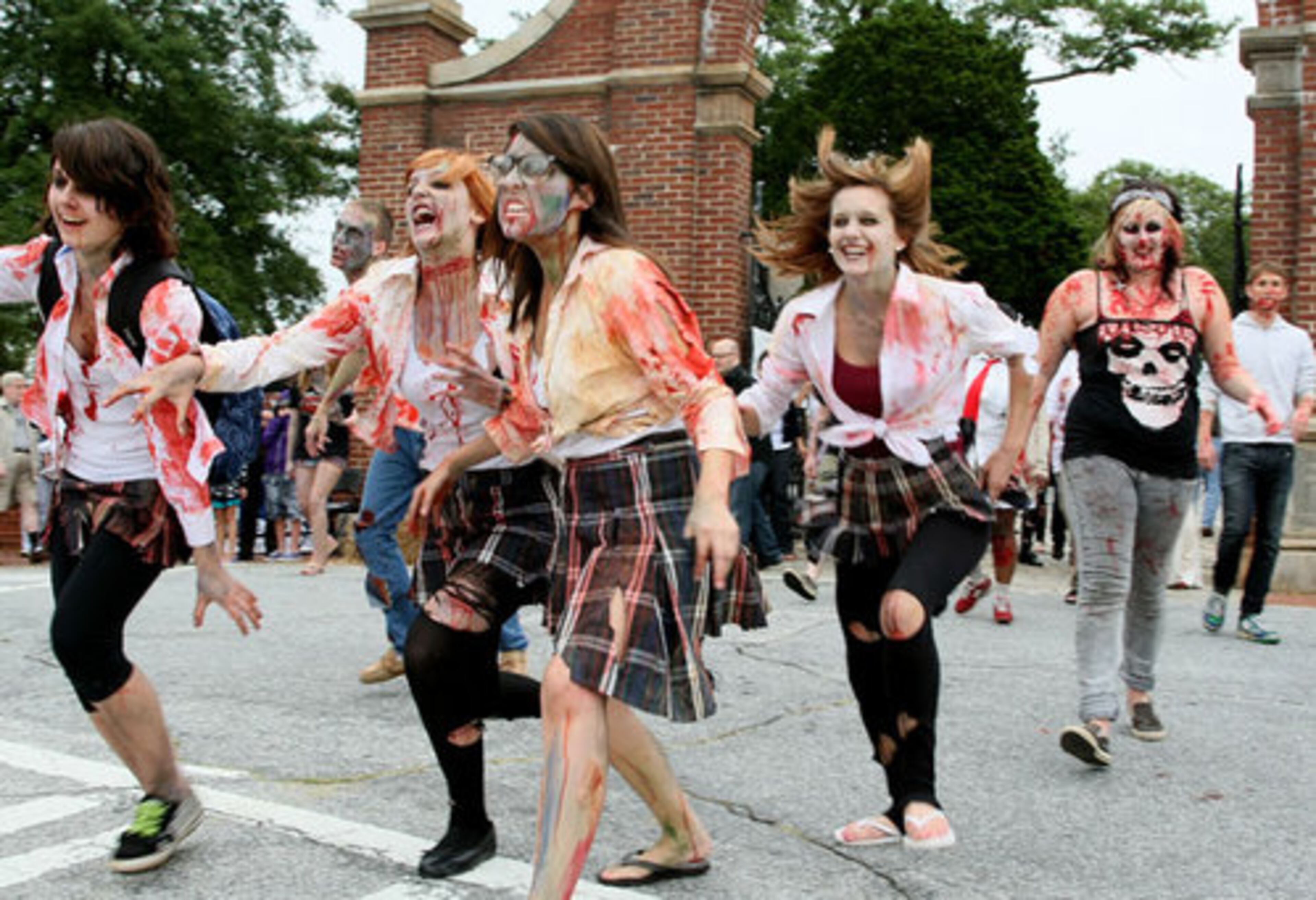 A group of Zombies run out of Oakland Cemetery to start the walk. The walk started at Lenny's Bar on Decatur Street, proceeded to Oakland Cemetery then downtown to Underground and back.