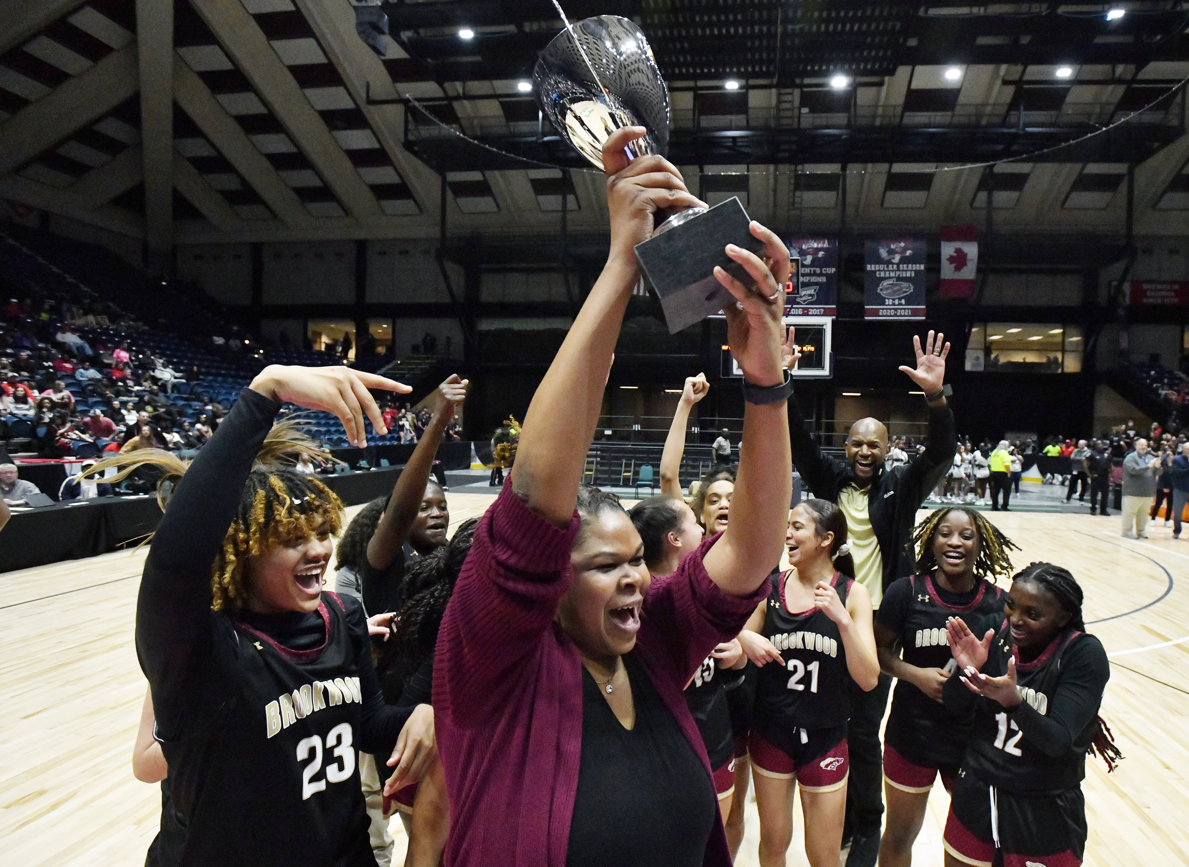 Brookwood's head coach Courtney Mincy holds up the championship trophy. (Hyosub Shin / Hyosub.Shin@ajc.com)