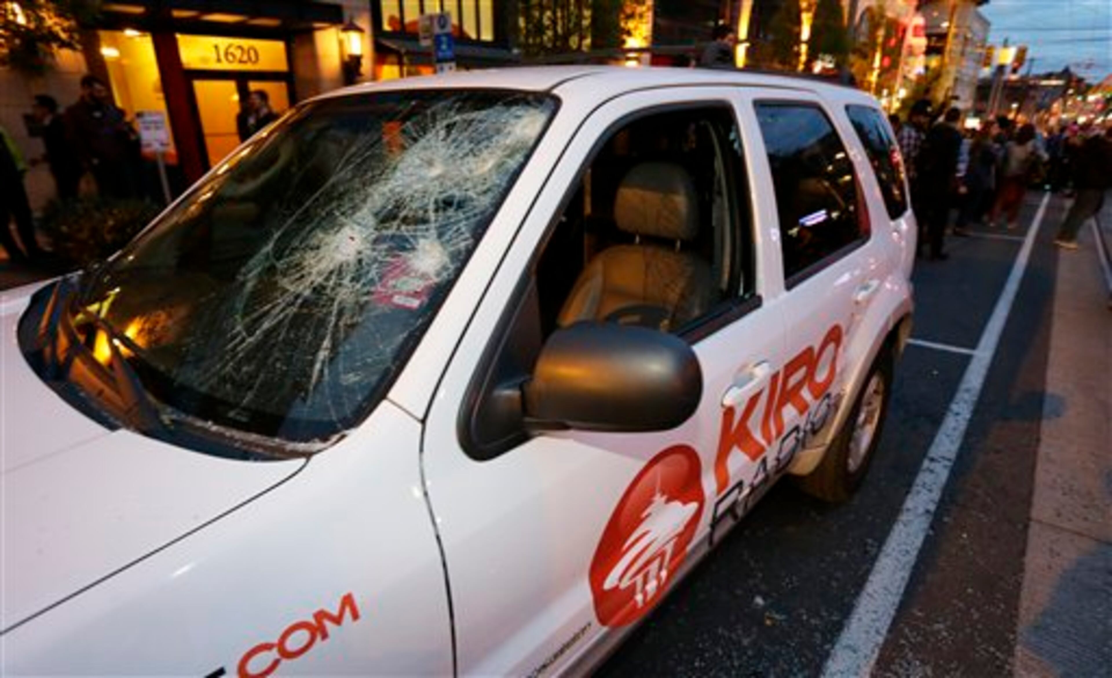 A vehicle belonging to KIRO radio is shown with its windows smashed during a May Day anti-capitalism march to begin, Friday, May 1, 2015 in Seattle. (AP Photo/Ted S. Warren)