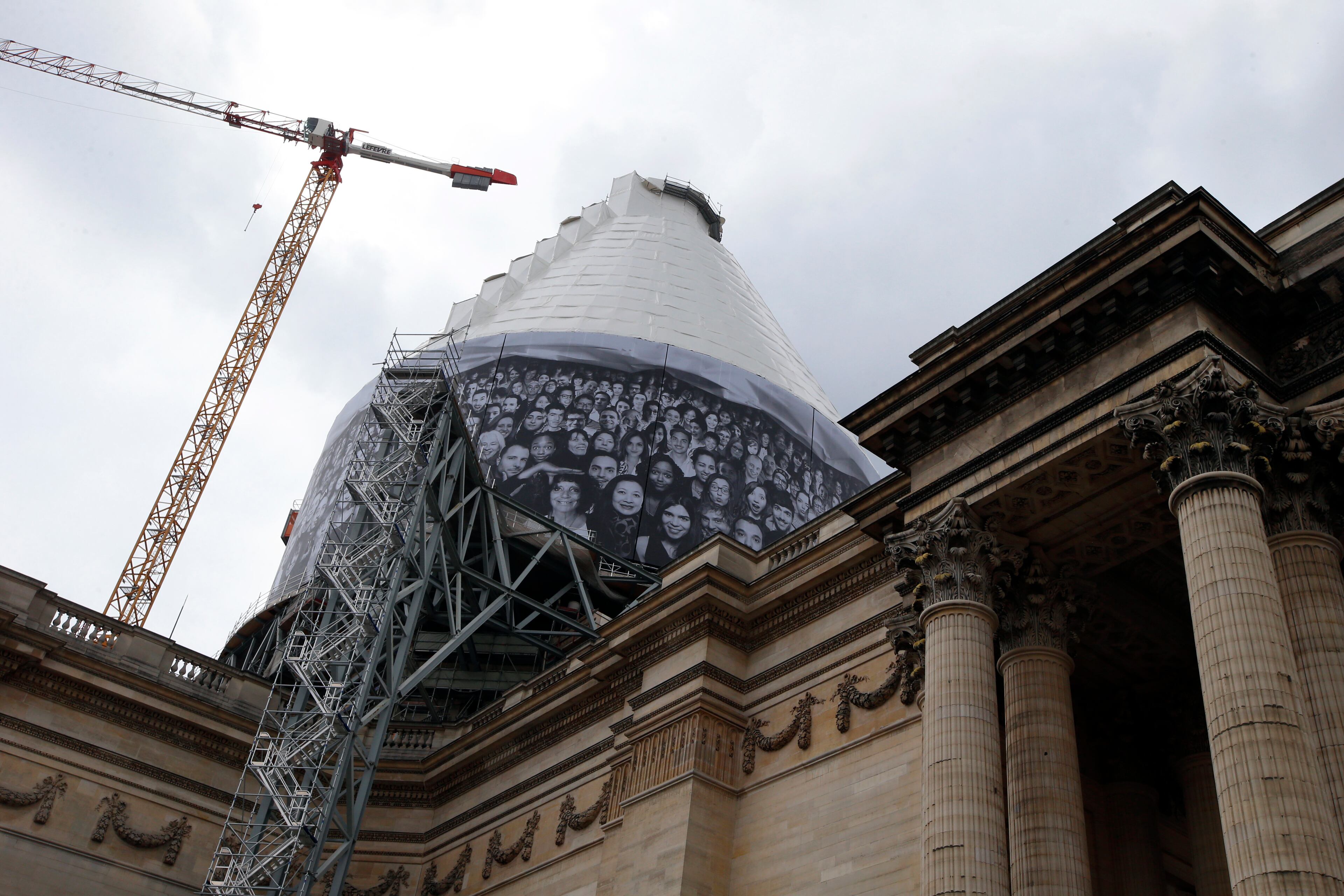 A giant photos of portraits by French street artist and photographer JR decorates the dome of the Pantheon during the presentation of his creation in Paris, Tuesday, June 3, 2014. French Government named JR to decorate with portraits the dome of Paris' Pantheon, that is the final resting place for 72 of France's renowned men, and just one woman, as the monument is undergoing a 2 year renovation. (AP Photo/Francois Mori)