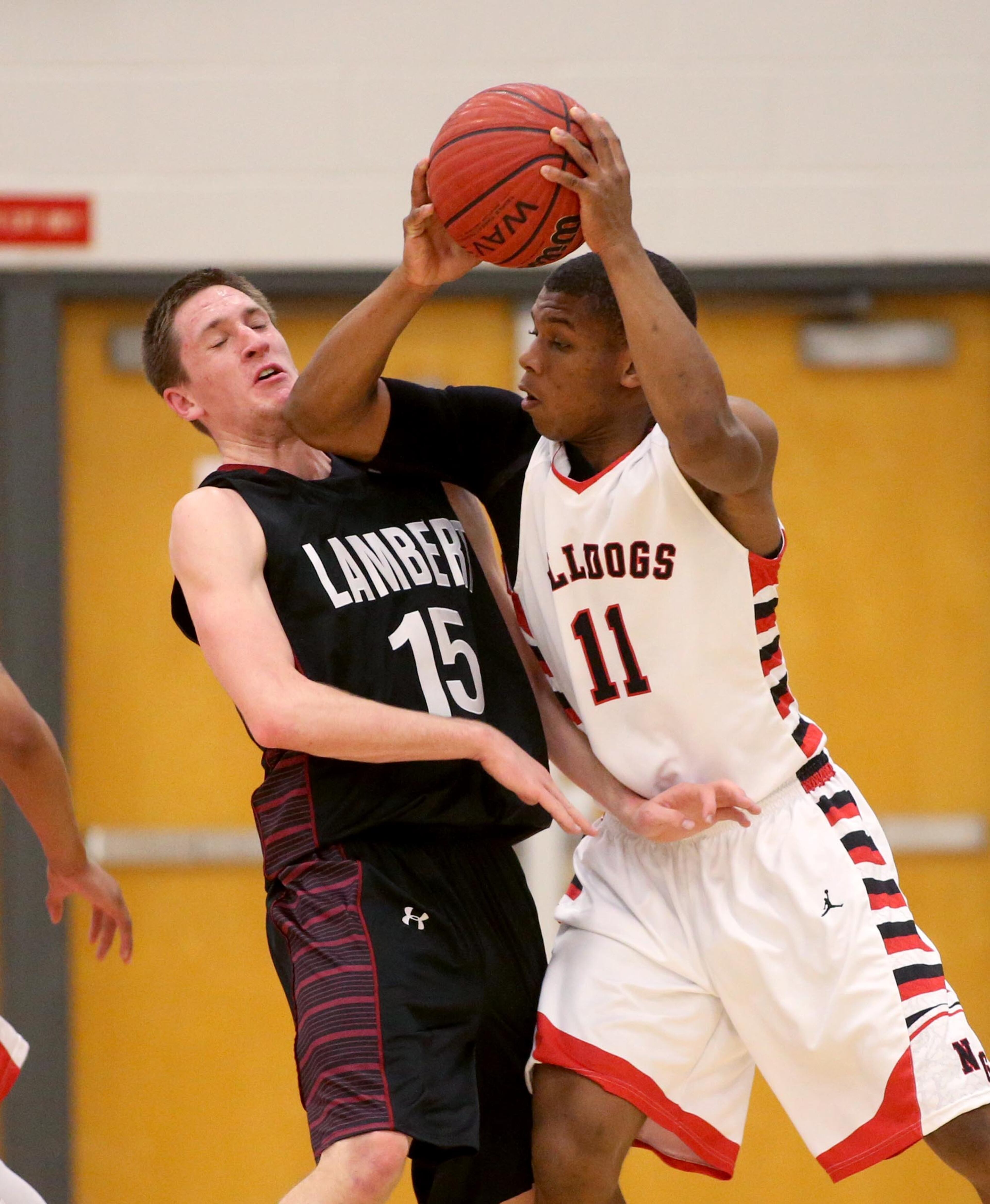 North Gwinnett's Jaye Stackhouse (11) gets pressured from Lambert's Joe Bates (15) in their game Tuesday night in Suwanee, Ga., February 25, 2014.