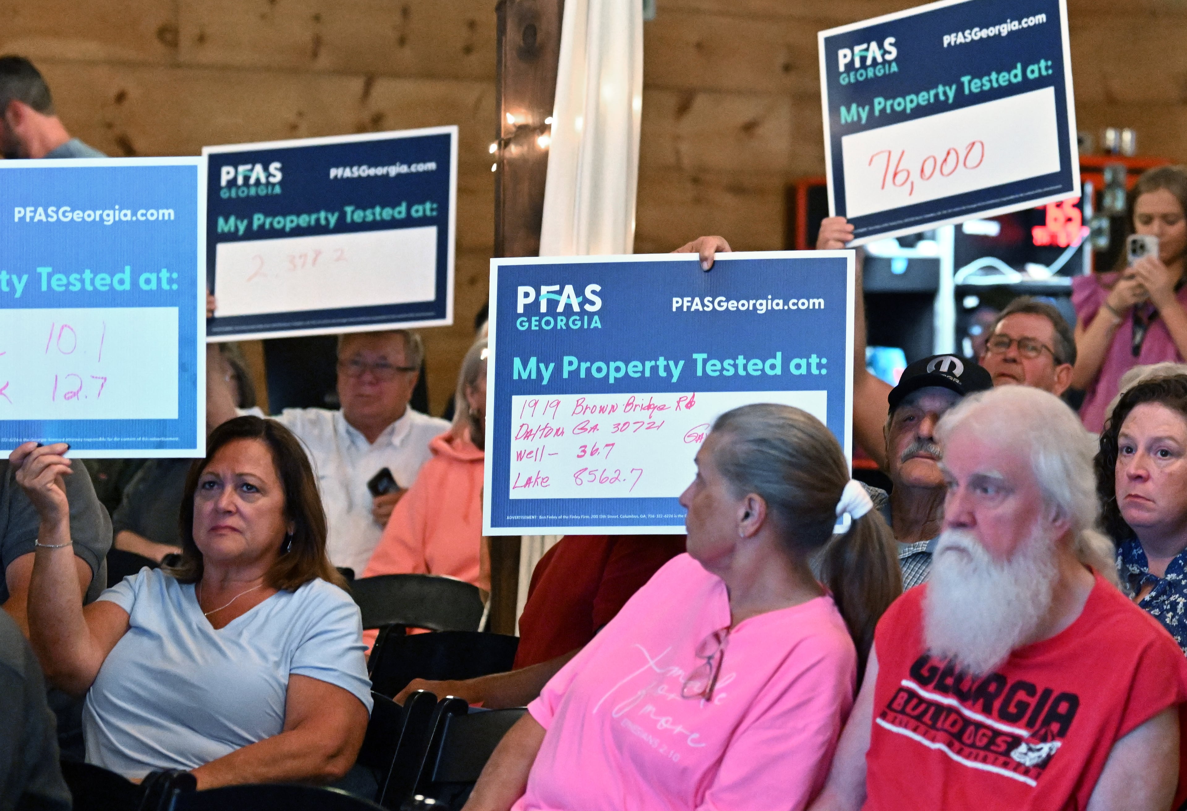 Attendees hold their water test results during a 2025 town hall meeting in Chatsworth to discuss area water contamination. (Hyosub Shin/AJC)