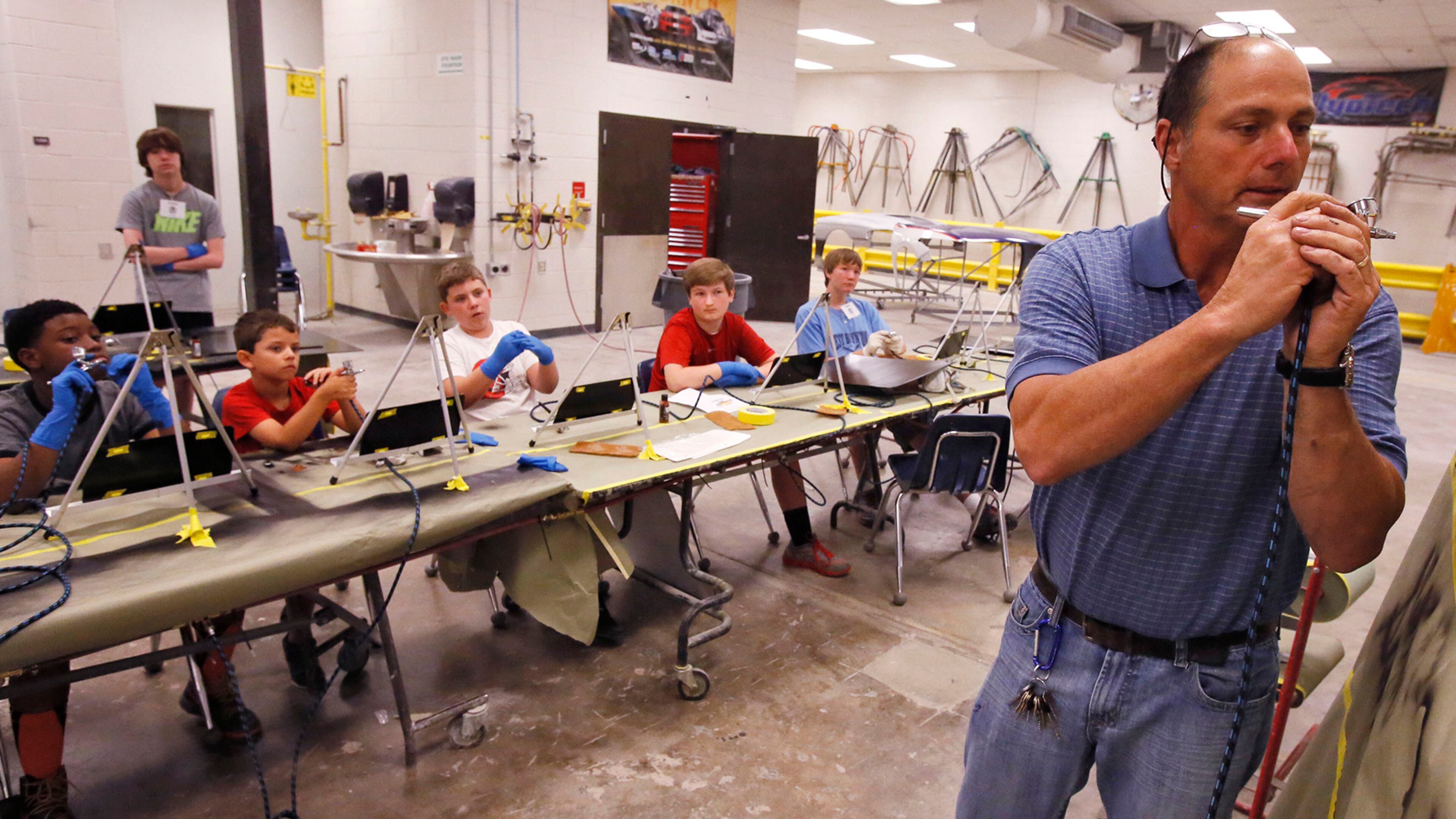 Instructor Sam Melaragno demonstrates air brush techniques for the students to practice in the Auto Collision and Repair shop. The Gwinnett County school district has a camp for middle school students to explore careers in science, law, construction and other subjects at the Maxwell High School of Technology in Lawrenceville.