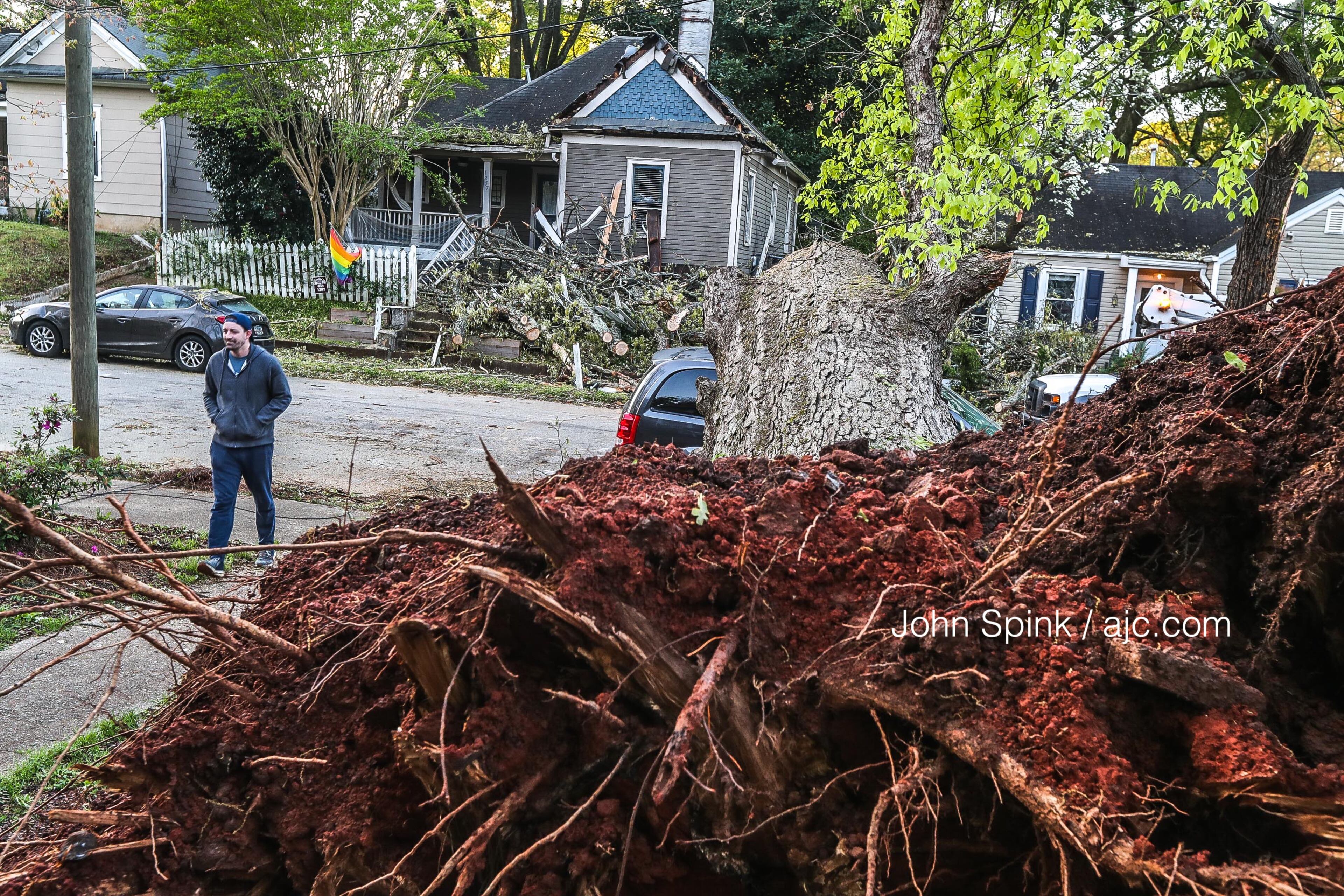 An uprooted tree in a neighbor’s yard fell across McPherson Avenue and onto a home in southeast Atlanta after fast-moving storms swept through the city at midday Tuesday.