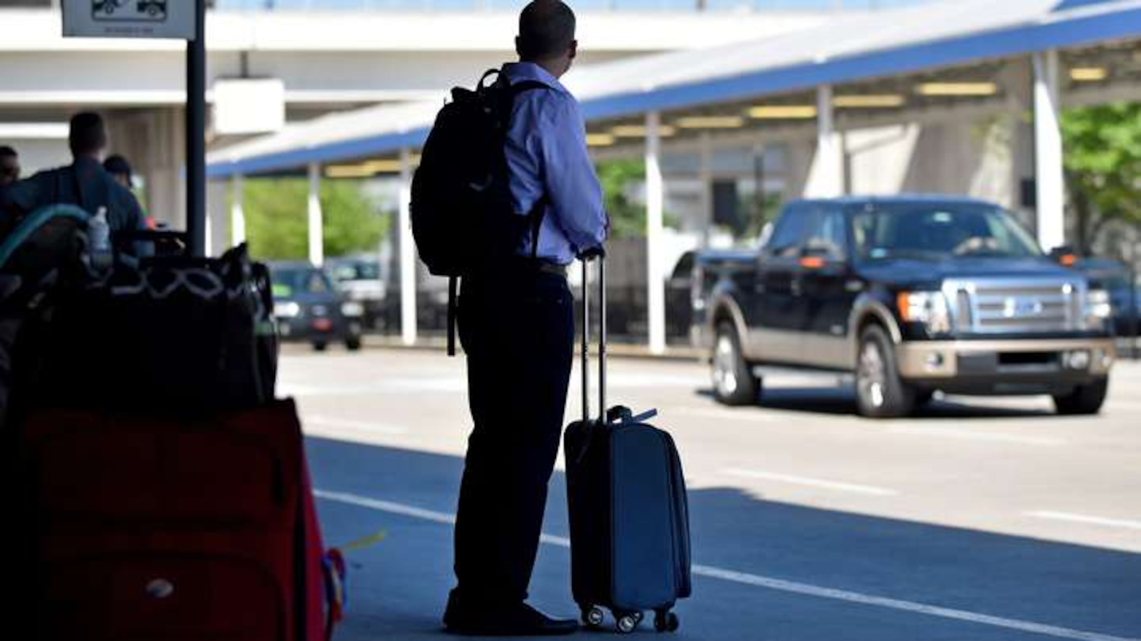 An arriving passenger waits for a ride at Hartsfield Jackson International Airport. BRANT SANDERLIN/BSANDERLIN@AJC.COM