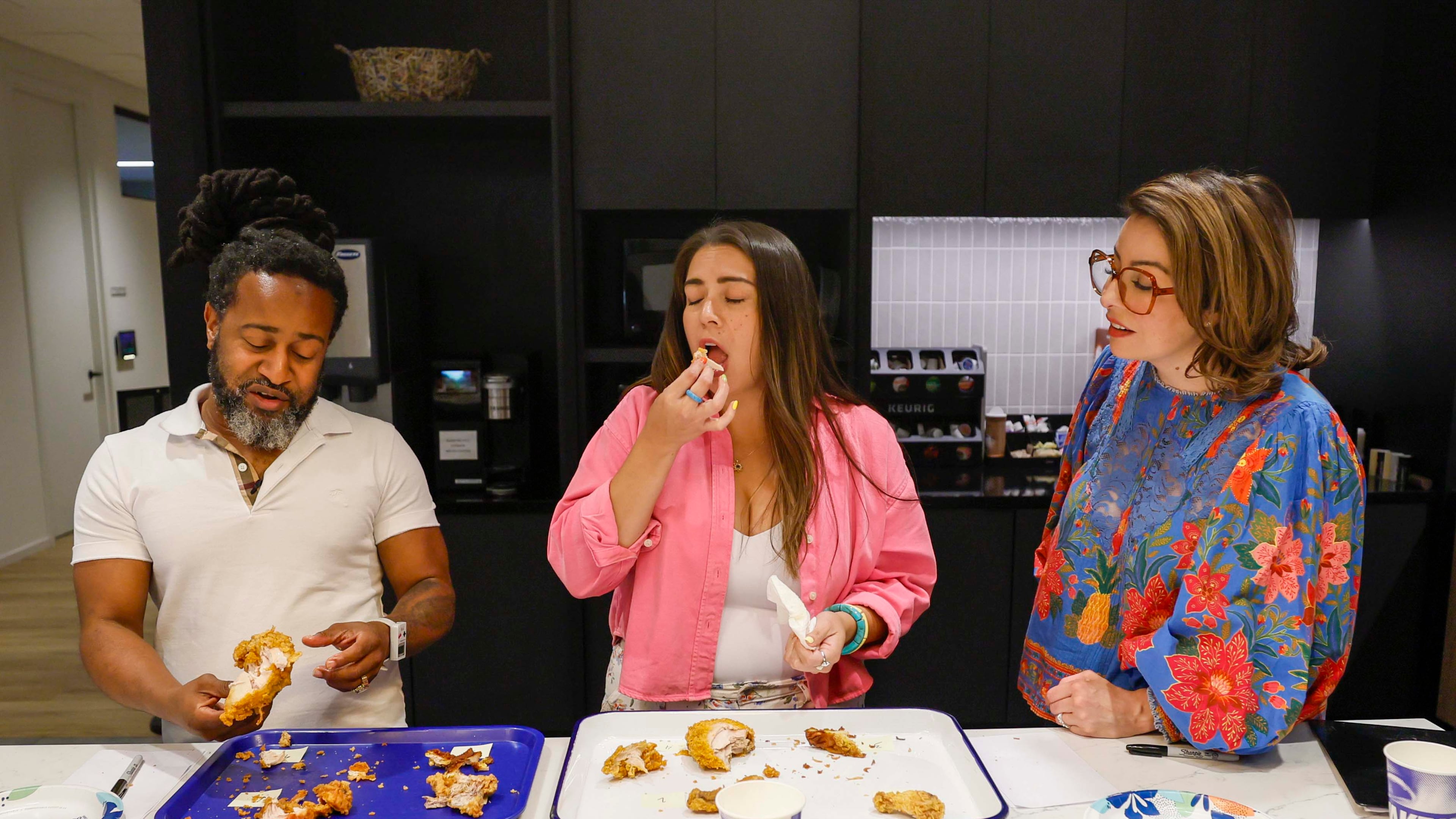 Daniela Cintron, editor at Discover Atlanta, center, reacts as she tastes a piece of fried chicken alongside Justin Brown, ATL50 expert panelist, during a contest to find Atlanta’s best fried chicken, held on Tuesday, Aug. 25, 2026, at the AJC office in Midtown. (Miguel Martinez/AJC)