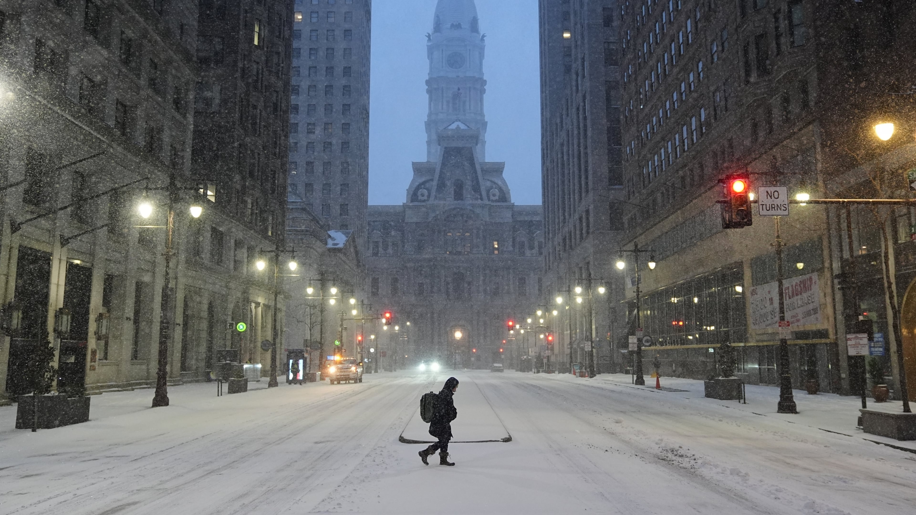 A person walks across a street during a winter storm in Philadelphia, Sunday, Jan. 25, 2026. (AP Photo/Matt Rourke)