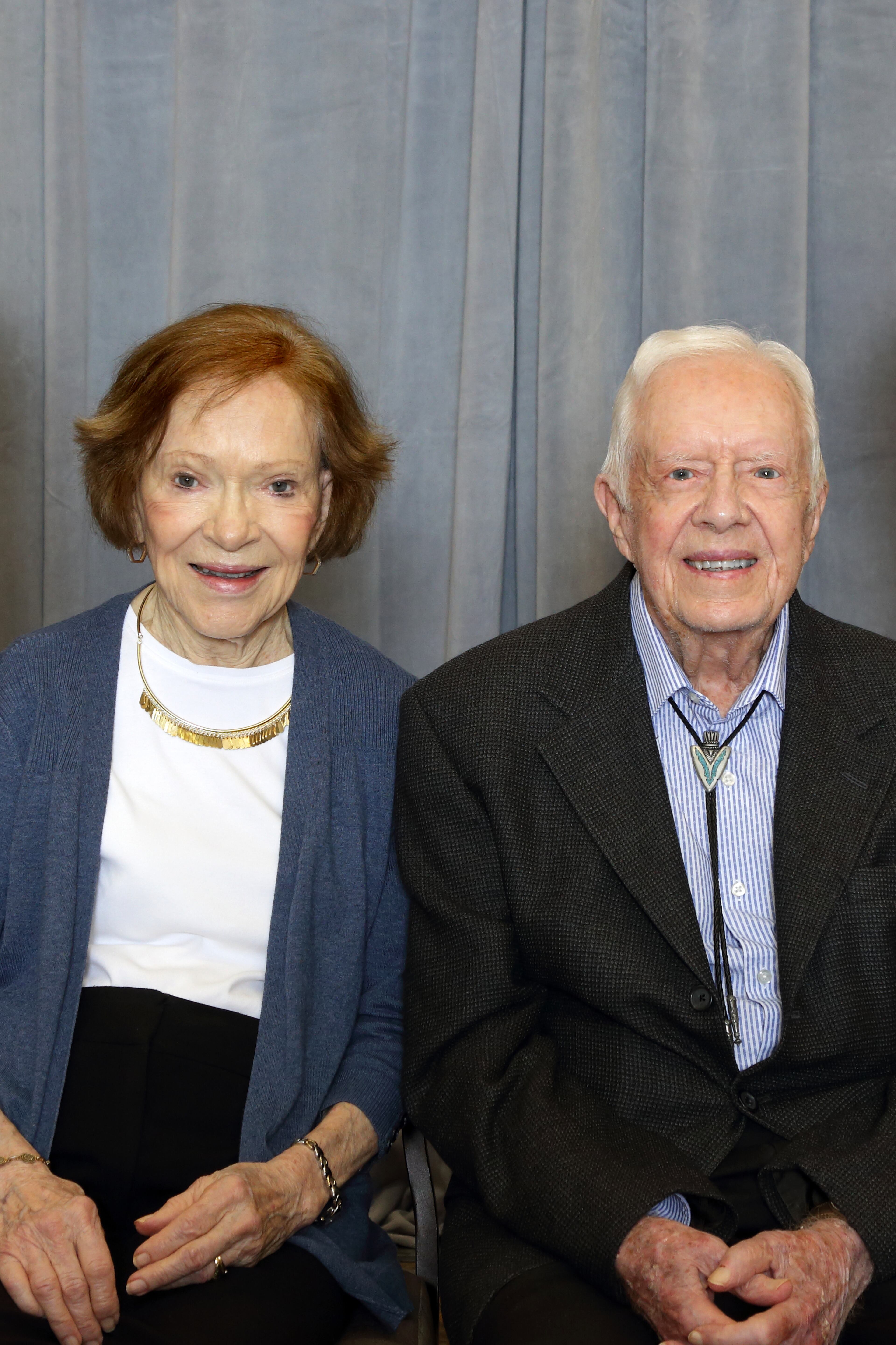 Former First Lady Rosalynn Carter and Jimmy Carter getting ready to sit down with attendees of The Carter Center Weekend, for individual photographs.