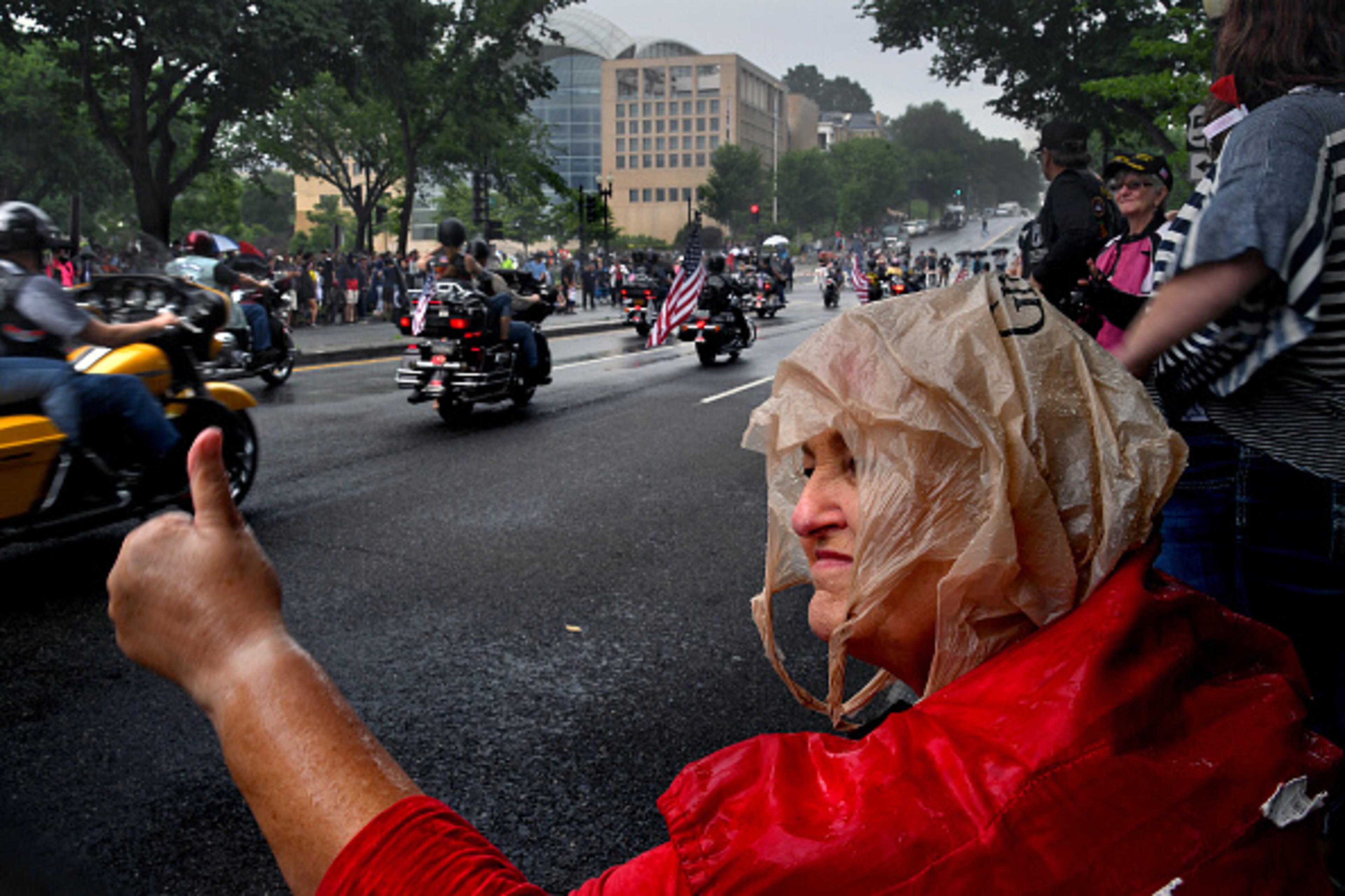 WASHINGTON DC -MAY 28: Barbara Hall from North Carolina (wearing a plastic bag as a head covering from the rain) gives a thumbs-up to passing participants in the Rolling Thunder event today. Thousands of motorcyclists swarmed the Washington, D.C. area today to take part for the 30th annual Rolling Thunder Memorial Day event. (Photo by Michael S. Williamson/The Washington Post via Getty Images)