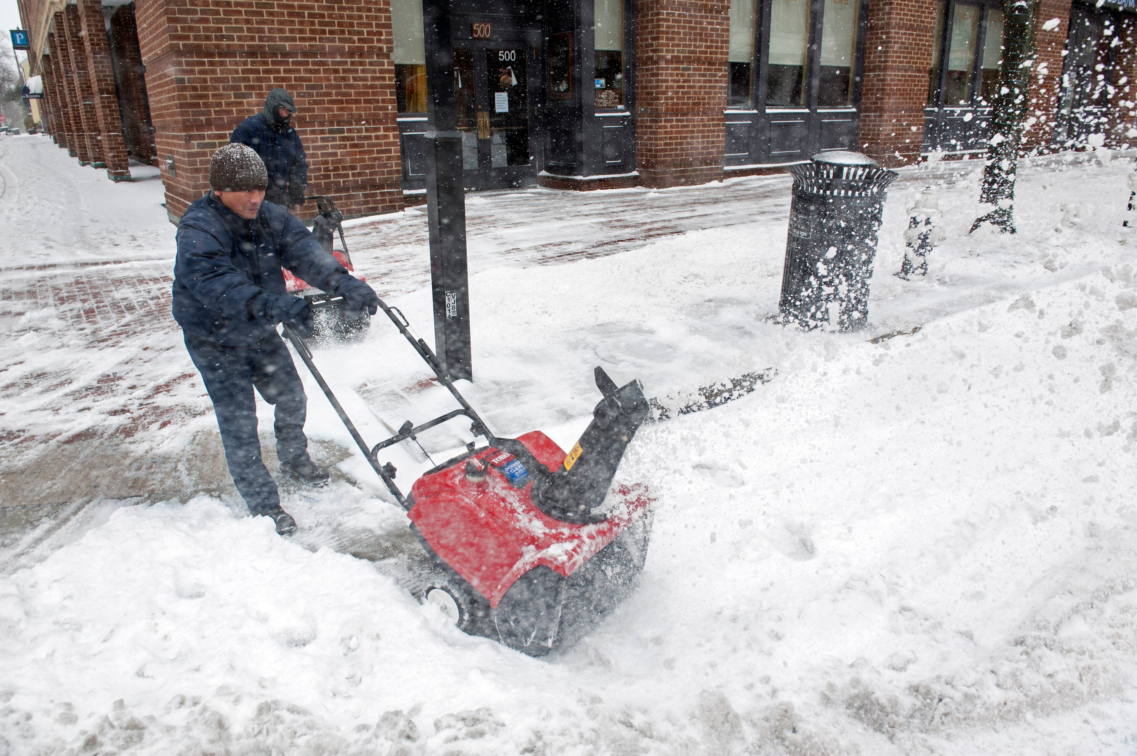 Workers clear snow from the sidewalks in Alexandria, Va., Monday, March 3, 2014. The National Weather Service has issued a Winter Storm Warning for the greater Washington Metropolitan region, prompting area schools and the federal government to close for the wintry weather. (AP Photo/Cliff Owen)