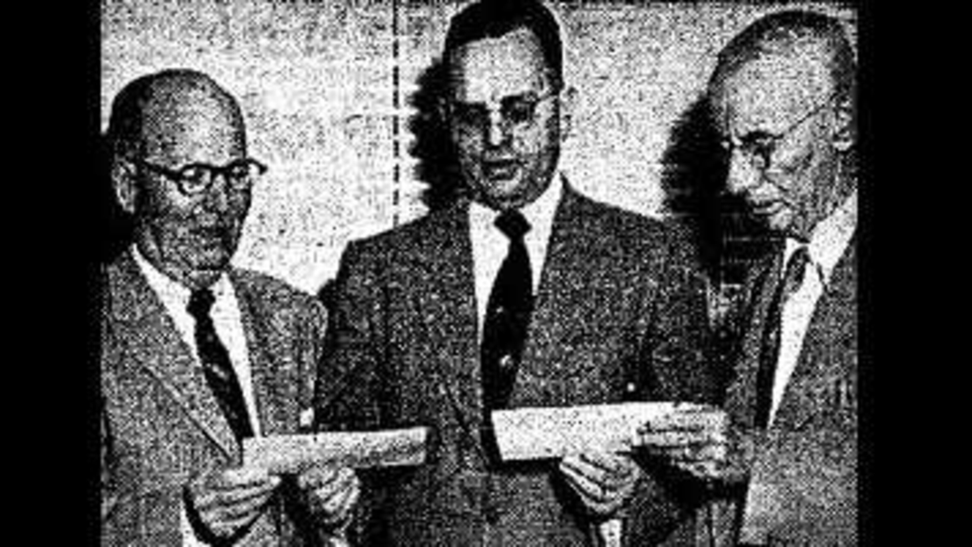 Atlanta and Fulton County officials receive large tax payment checks from a Southern Bell Telephone and Telegraph Co. district manager (center), as seen in an Atlanta Constitution article from Nov. 26, 1953.