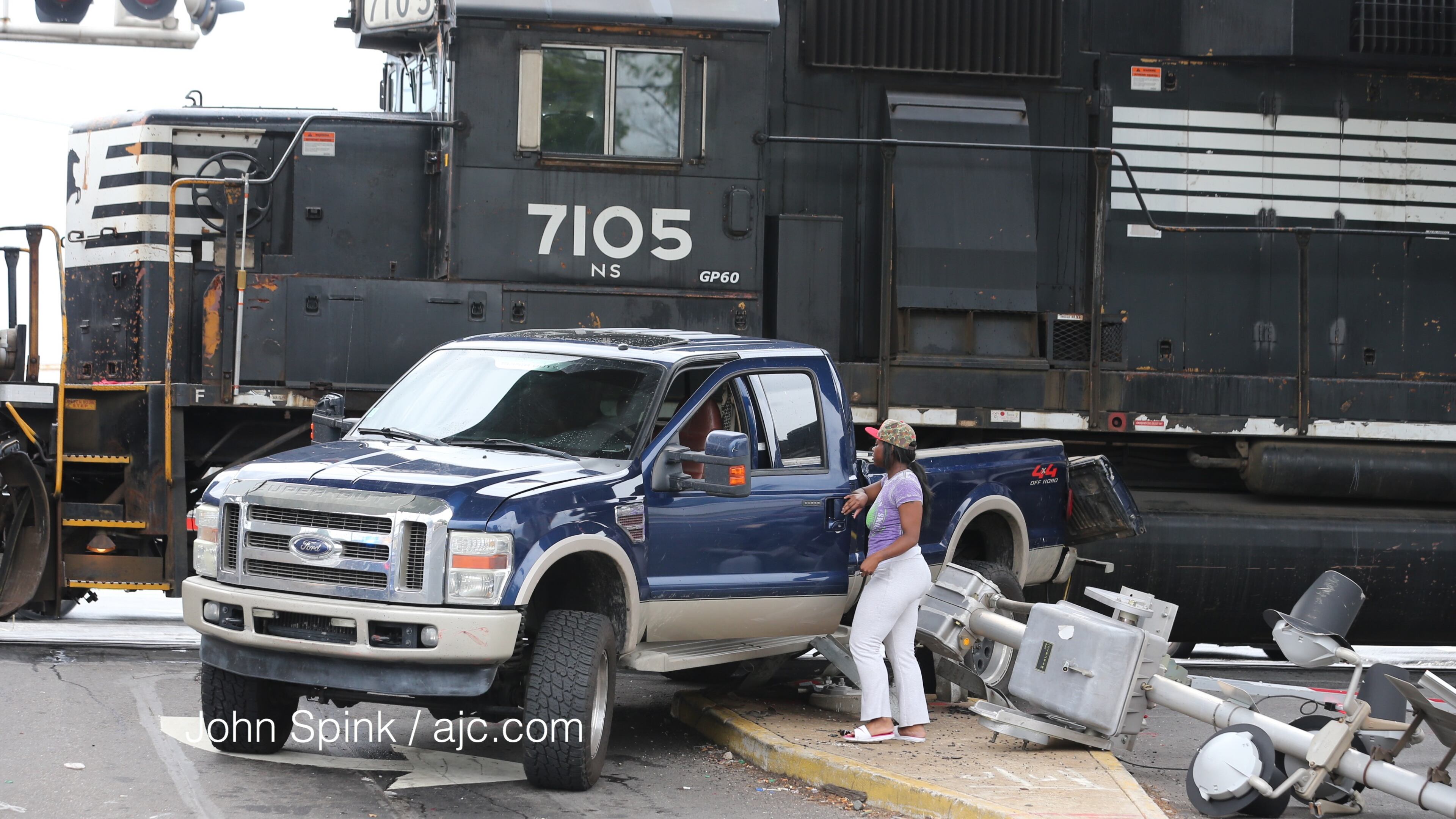 Shakira Stokes retrieves her father's belongings after a Norfolk Southern train hit his truck on Lee Street near Sylvan Road. JOHN SPINK / JSPINK@AJC.COM
