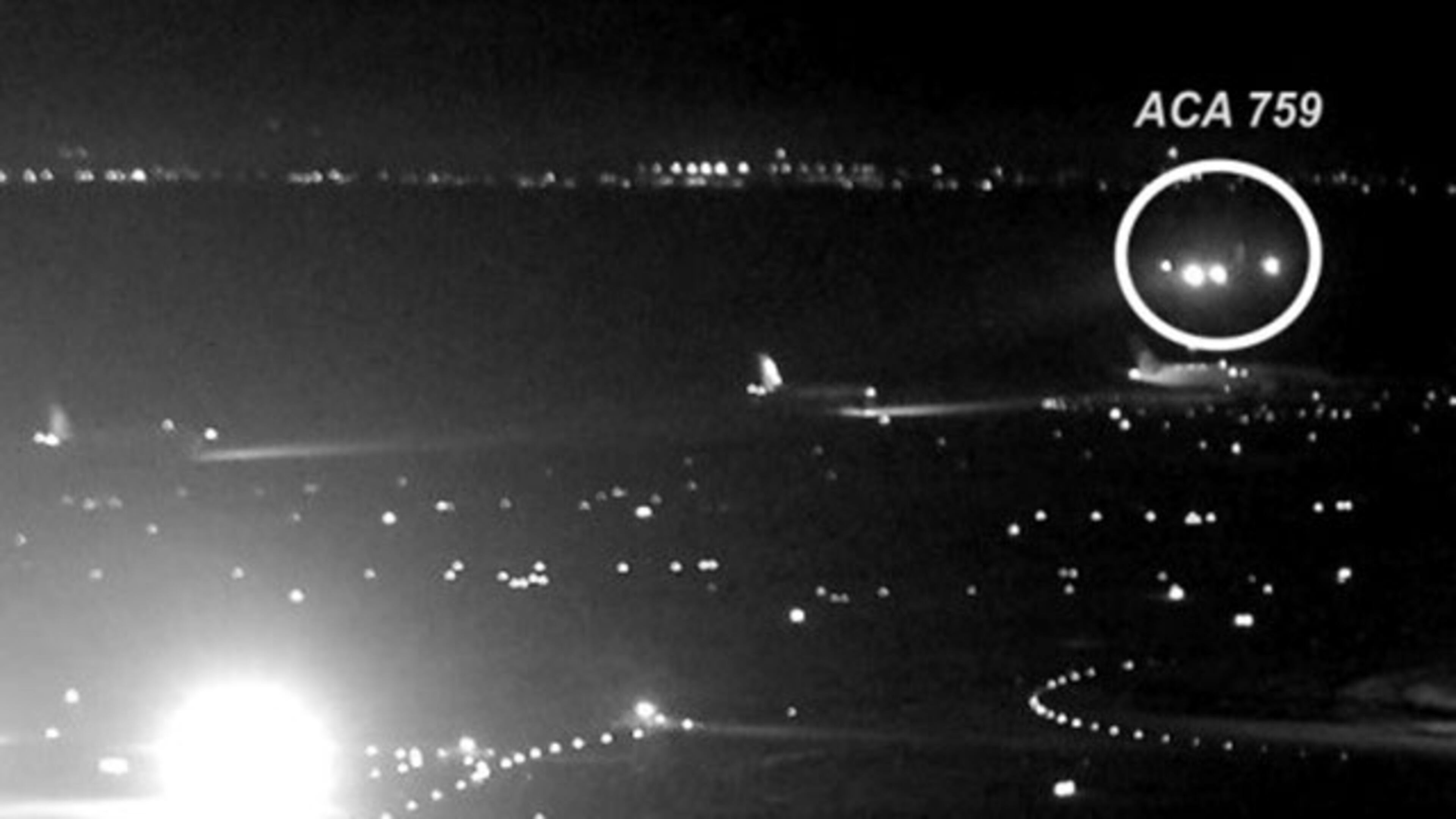 In a photo released by the National Transportation Safety Board, Air Canada flight 759 can be seen flying just a few dozen feet above one of four planes waiting for takeoff clearance on Friday, July 7, 2017, at San Francisco International Airport.