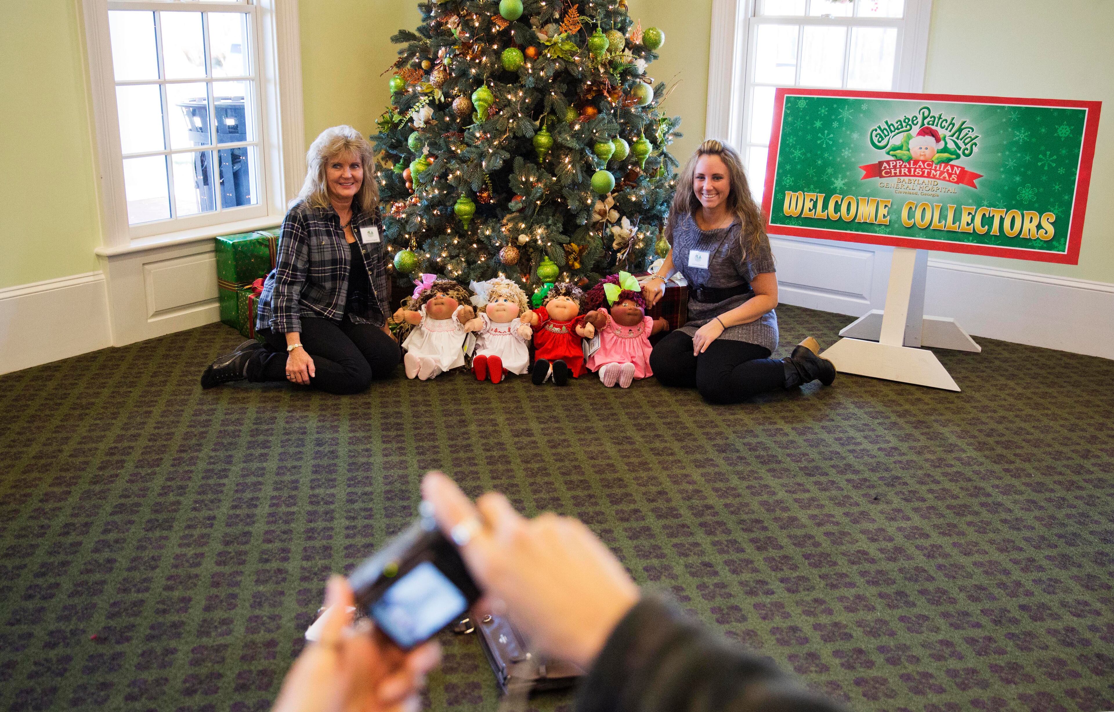 In this Nov. 21, 2014 photo, Rebecca Wagner, left, and daughter Victoria, of Cleveland, Ohio, have their picture taken with Cabbage Patch Kids at a collector's convention at Babyland General Hospital, the birthplace of Cabbage Patch Kids, in Cleveland, Ga. Wagner has passed her love of Cabbage Patch kids on to her 24-year-old daughter, Victoria, and the two have more than a thousand dolls. They make the trip from their home in Cleveland, Ohio, to Babyland General several times a year. "I've been here since I was a little girl, and I absolutely love it," Victoria Wagner said. "It's so magical here, you feel like this is home." (AP Photo/David Goldman)