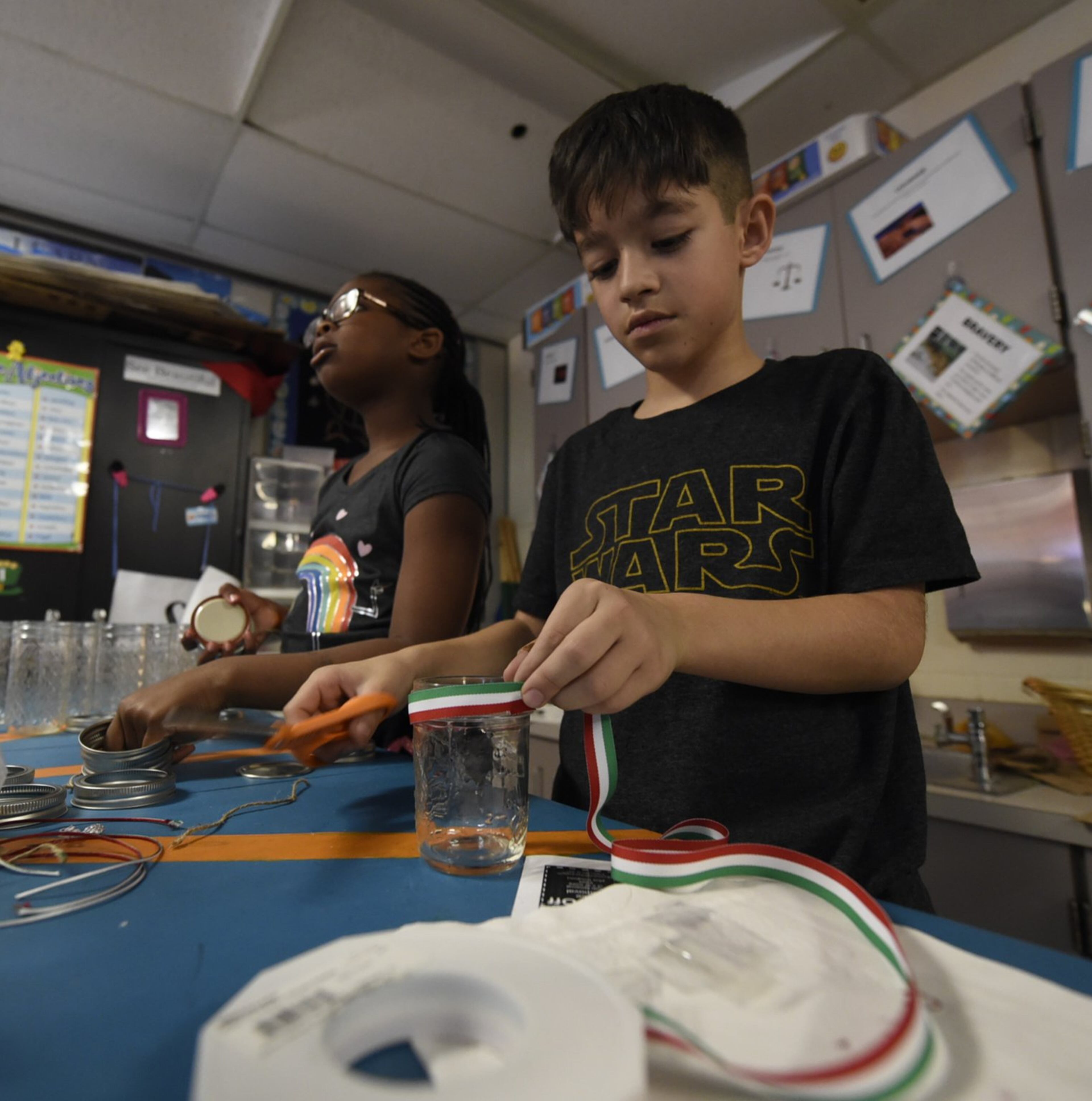 Brandon Gonzalez (right) and Madison Hanson put together table center pieces during a preparation session for the restaurant.
