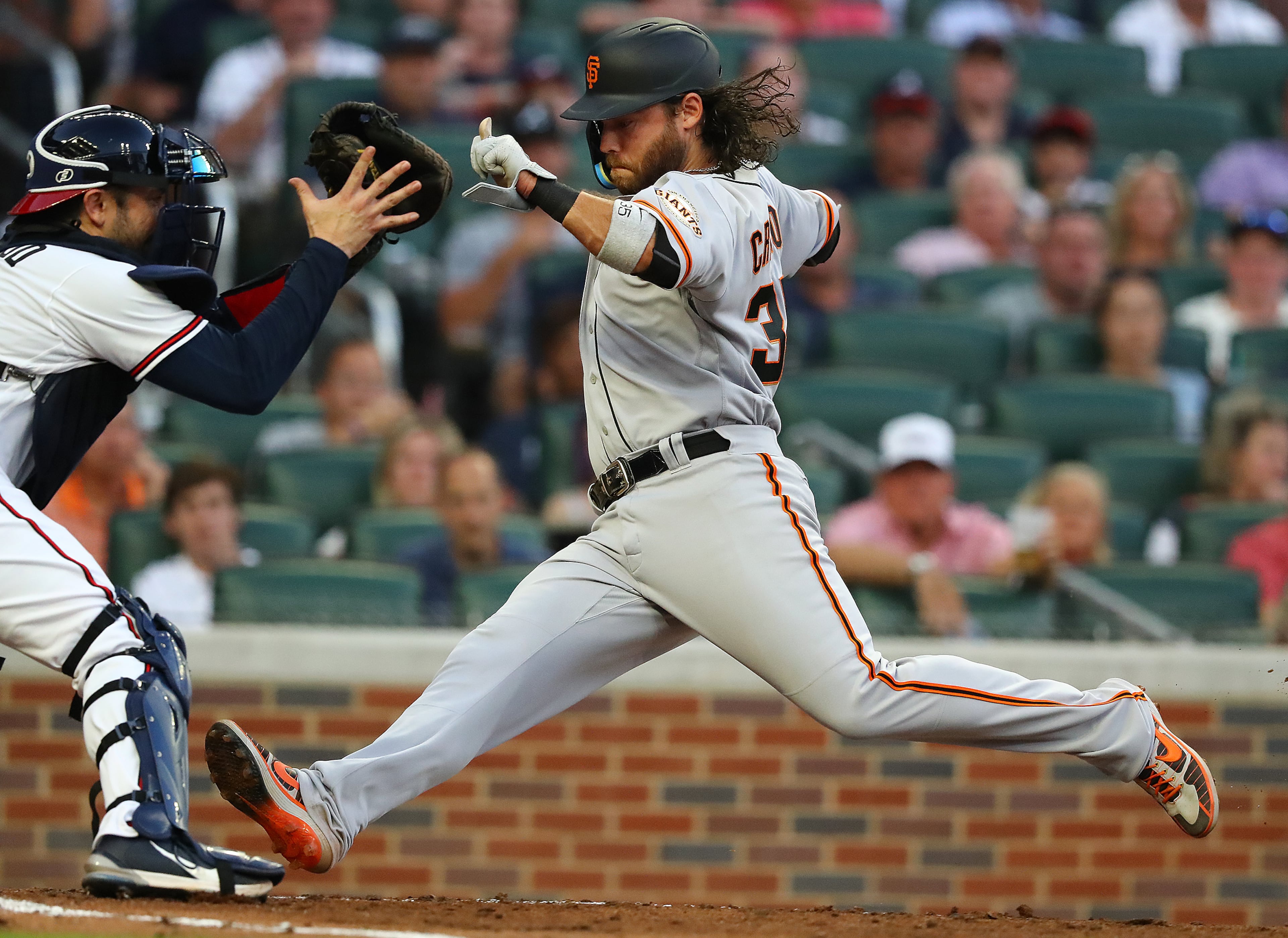 Giants shortstop Brandon Crawford races the throw home to Atlanta Braves catcher Travis d' Arnaud during the fourth inning of a MLB baseball game on Tuesday, June 21, 2022, in Atlanta. Crawford was called out on the play but after a review was ruled safe to take a 6-5 lead. “Curtis Compton / Curtis.Compton@ajc.com”