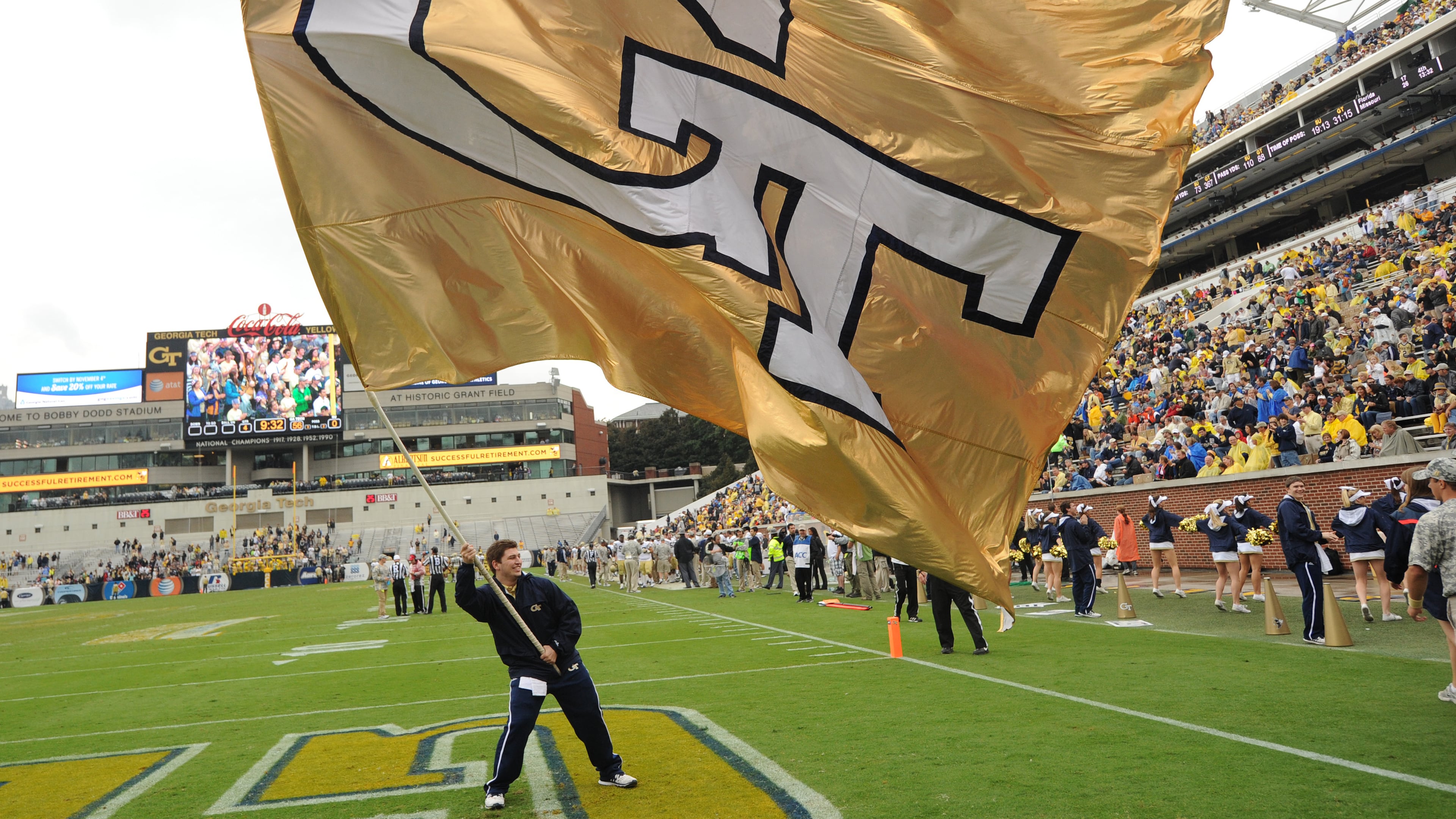 A Georgia Tech cheerleader waves the giant GT flag after a Georgia Tech touchdown in Bobby Dodd Stadium on Saturday, October 19, 2013. Georgia Tech won the game 56-0.