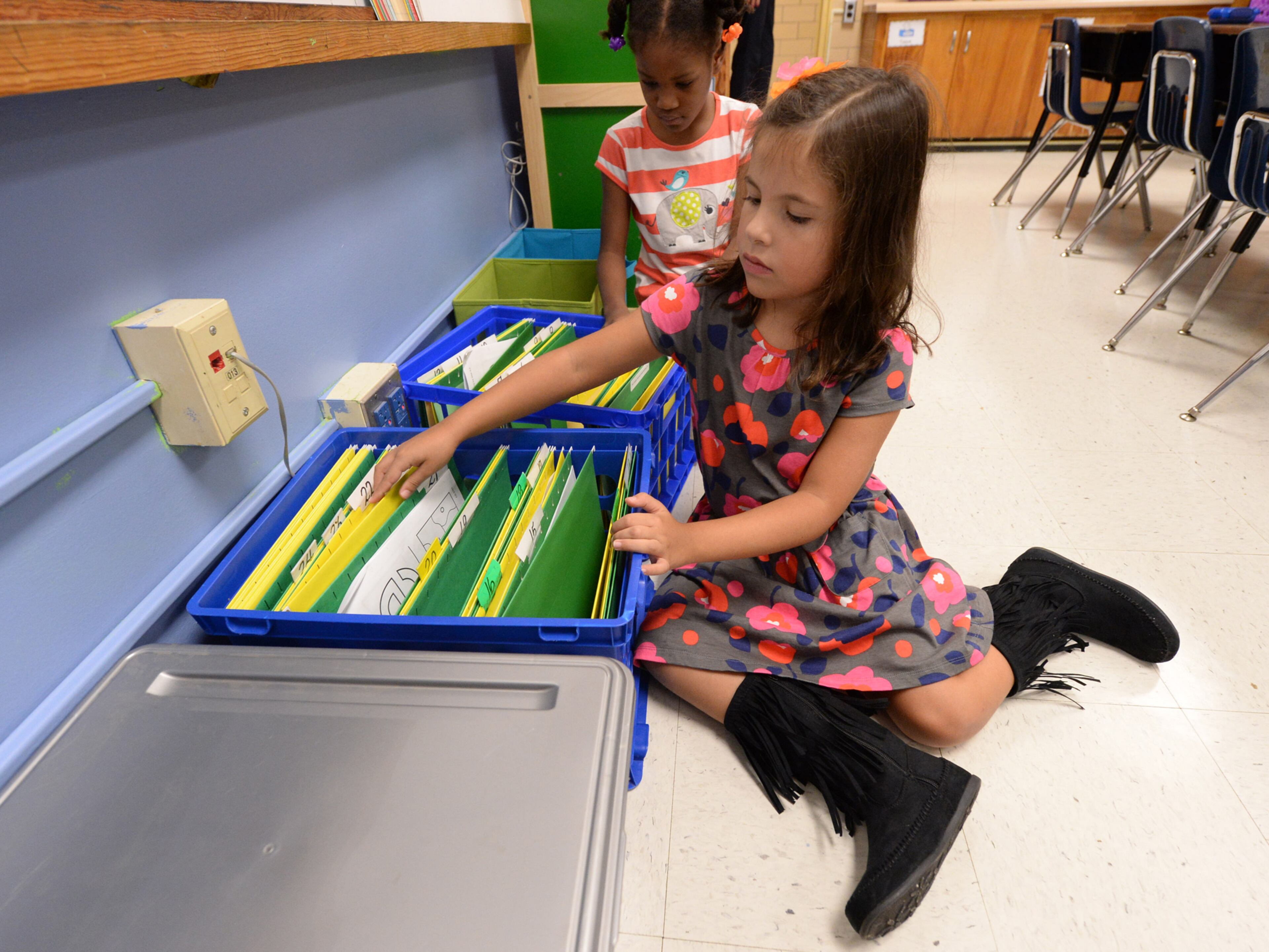 Emma Lopez places her first assignment in the class file on the first day of school at Midvale Elementary on Monday, August 12, 2013. JOHNNY CRAWFORD / JCRAWFORD@AJC.COM