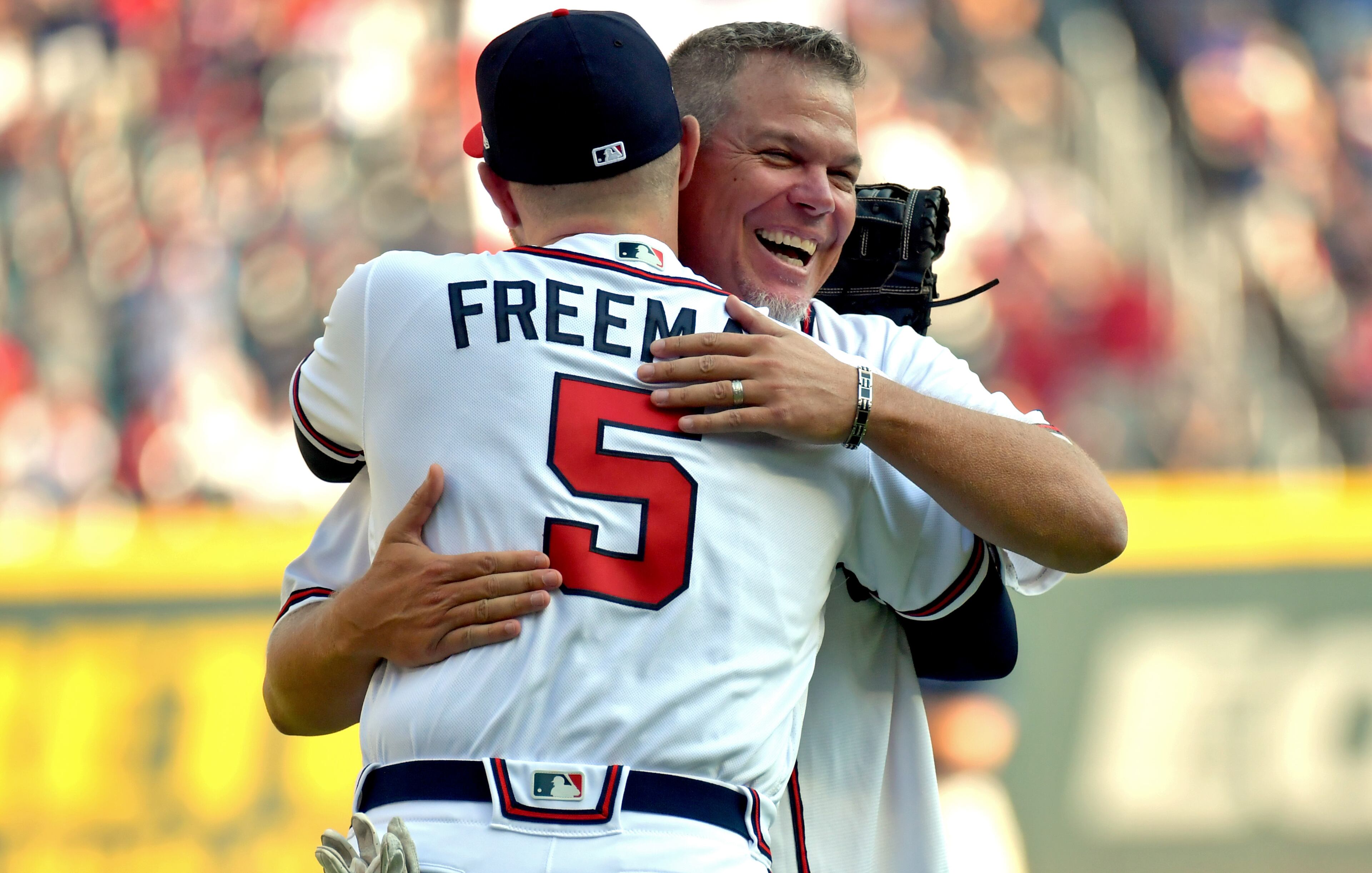 Former Atlanta Braves third baseman Chipper Jones hugs Freddie Freeman (5) after Jones threw out the ceremonial pitch before their game against the St. Louis Cardinals in Game 1 of the best-of-five National League Division Series at SunTrust Park on Thursday, October 3, 2019. (Hyosub Shin / Hyosub.Shin@ajc.com)