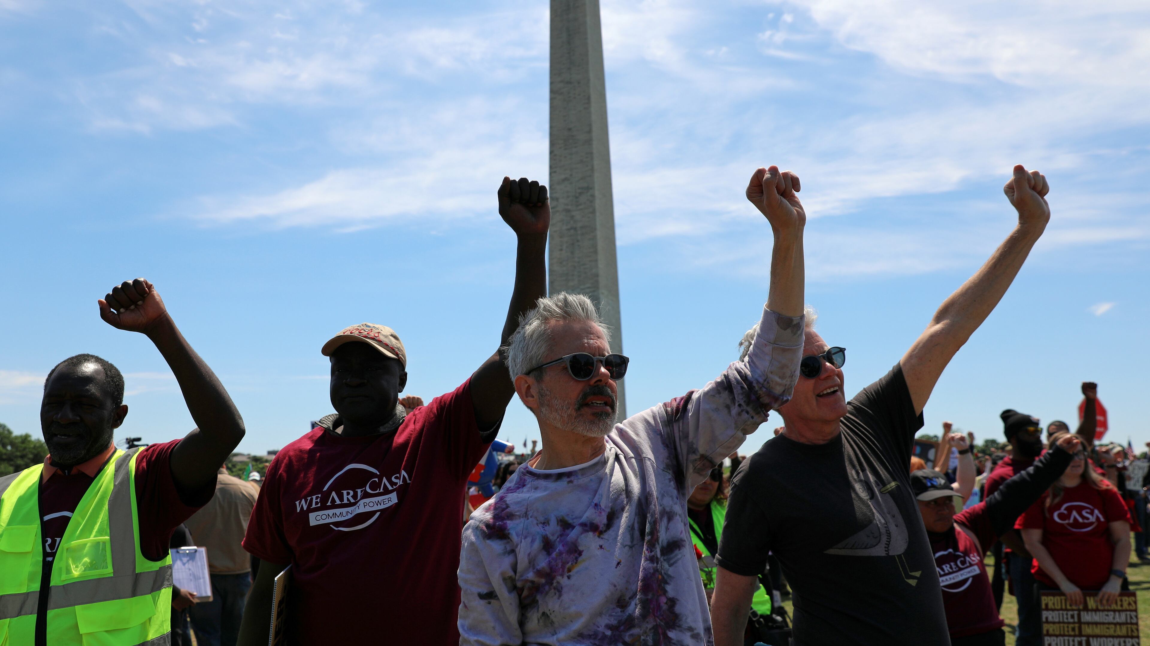 Demonstrators march as they rally at the National Mall during a May Day protest Friday, May 1, 2026, in Washington. The Washington Monument is in the background, (AP Photo/Rahmat Gul)