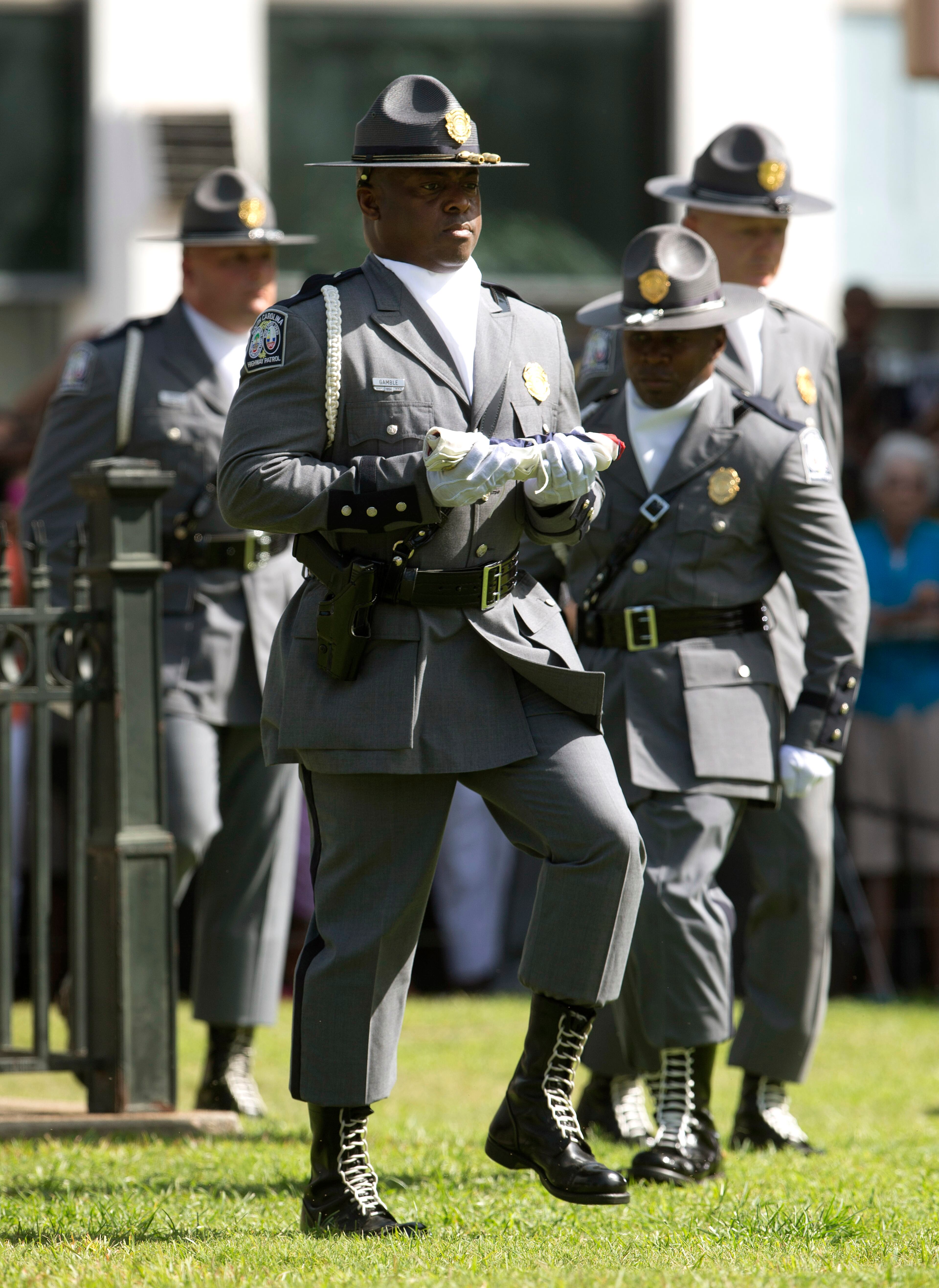 An honor guard from the South Carolina Highway patrol removes the Confederate battle flag from the Capitol grounds Friday, July 10, 2015, in Columbia, S.C. The Confederate flag was lowered from the grounds of the South Carolina Statehouse to the cheers of thousands on Friday, ending its 54-year presence there and marking a stunning political reversal in a state where many thought the rebel banner would fly indefinitely. (AP Photo/John Bazemore)